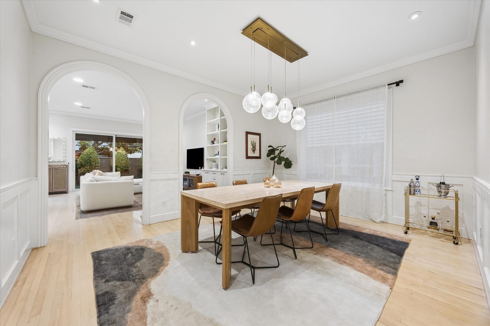 Extra-large formal dining room with beautiful hardwood floors and designer lighting, seamlessly connecting the formal living room with the family room for effortless entertaining and an exceptional flow throughout the home.