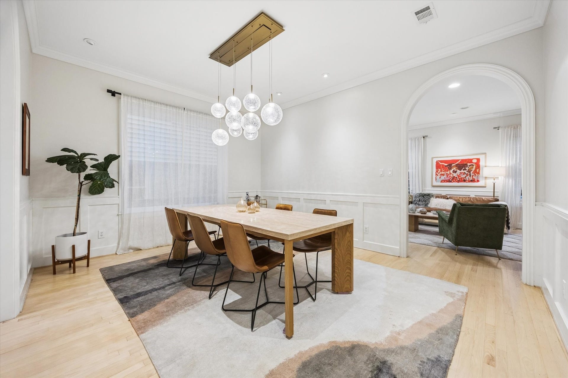 Another view of the expansive formal dining room highlights its elegant proportions, designer lighting and graceful arched opening to the formal living roomideal for large gatherings and entertaining.