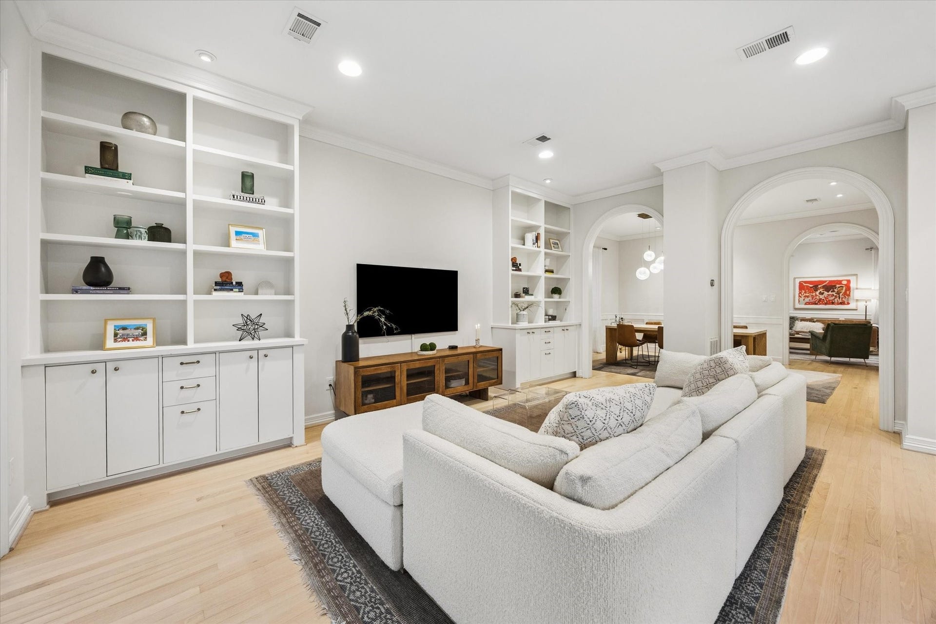 Another view highlights the wonderful flow of the home, with the family room opening through graceful arched passages to the dining and formal living spaces.