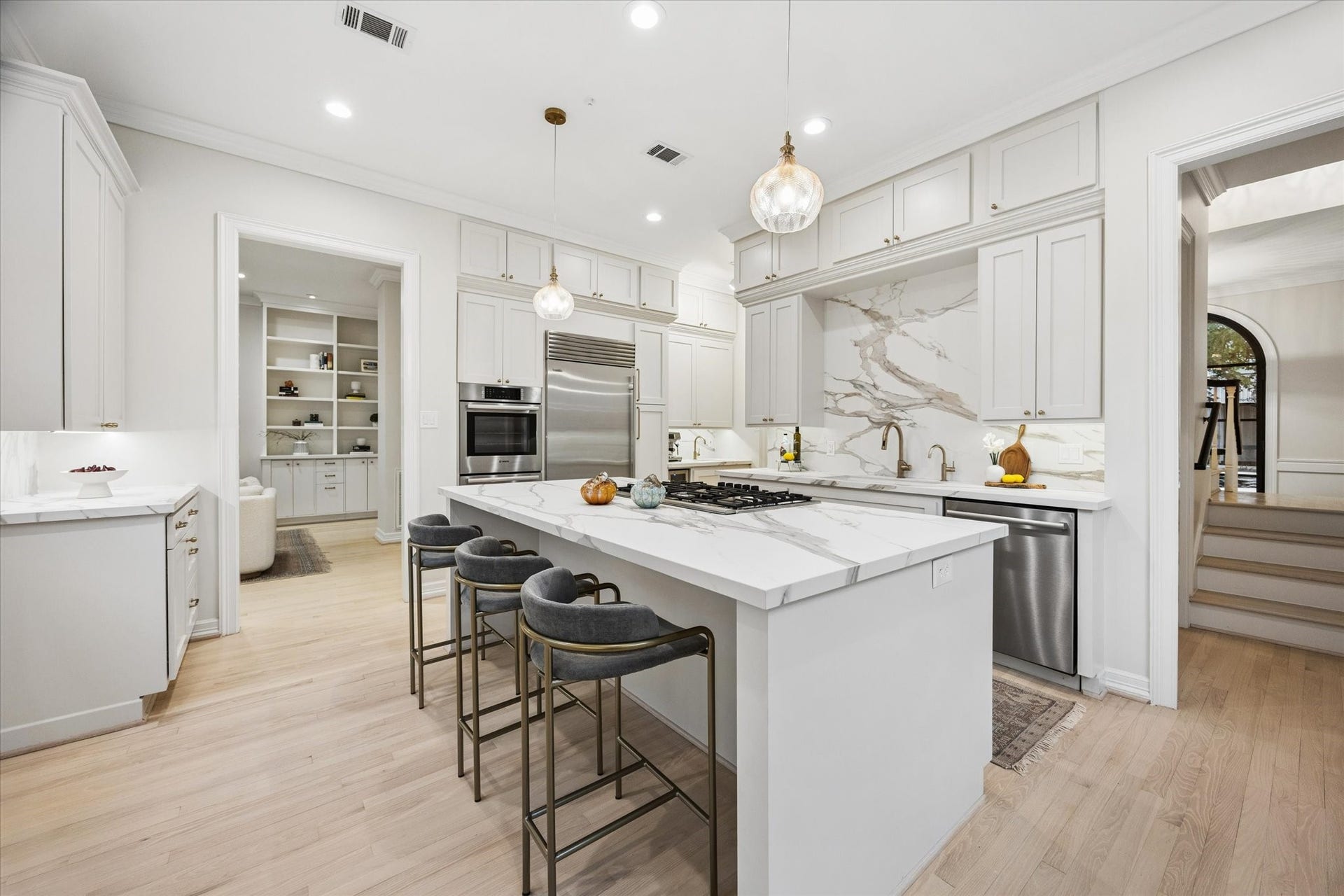 Ergonomically designed kitchen with floor-to-ceiling cabinetry, two large windows filling the space with natural light, and an oversized center island that creates a wonderful gathering place for the family.