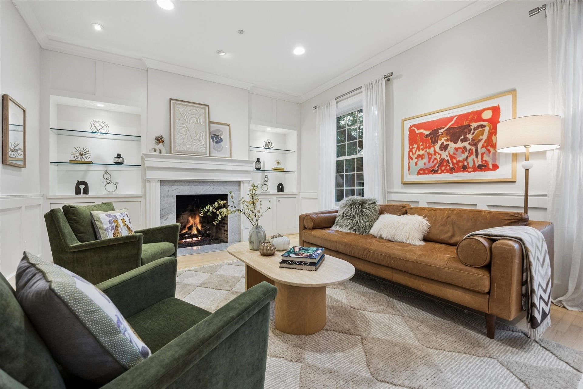 A beautifully proportioned formal living room combines timeless architectural details with a fresh, sophisticated feel, featuring hardwood floors, custom built-ins, a classic fireplace and abundant natural light.