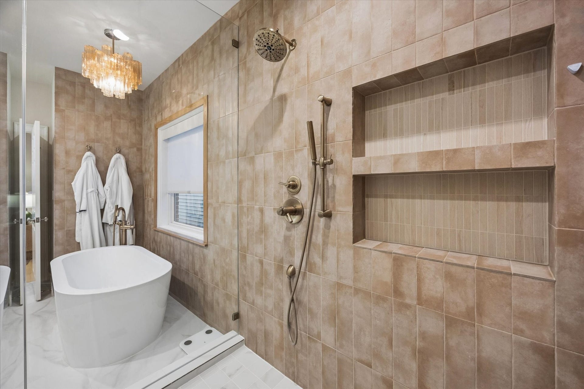 Oversized walk-in shower with dual showerheads, handheld spray and built-in niches, creating a luxurious spa-like experience.