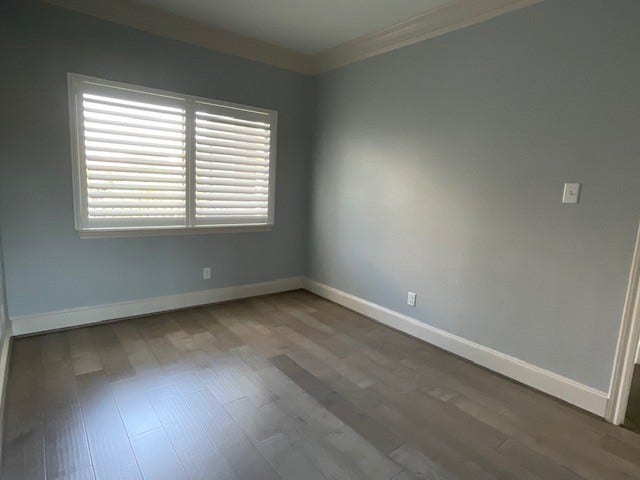 Large picture window adorned by Plantation Shutters in guest bedroom.
Beautiful views of lush landscaping and lovely estate homes.
