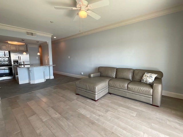 Beautiful wood flooring and ceiling fan in living room