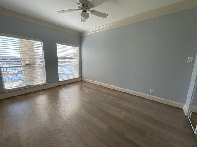 Wake up to views of marina cove and Lake Conroe from two picture windows in Primary Bedroom