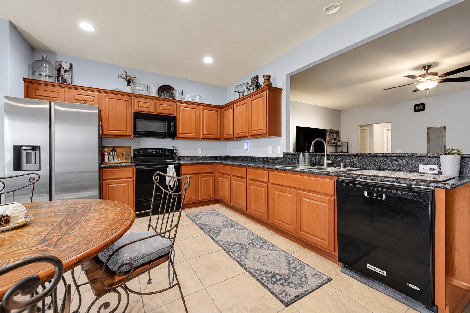 Spacious kitchen with elegant wooden cabinetry, sleek stainless steel appliances, and a cozy dining nook, perfect for family gatherings.