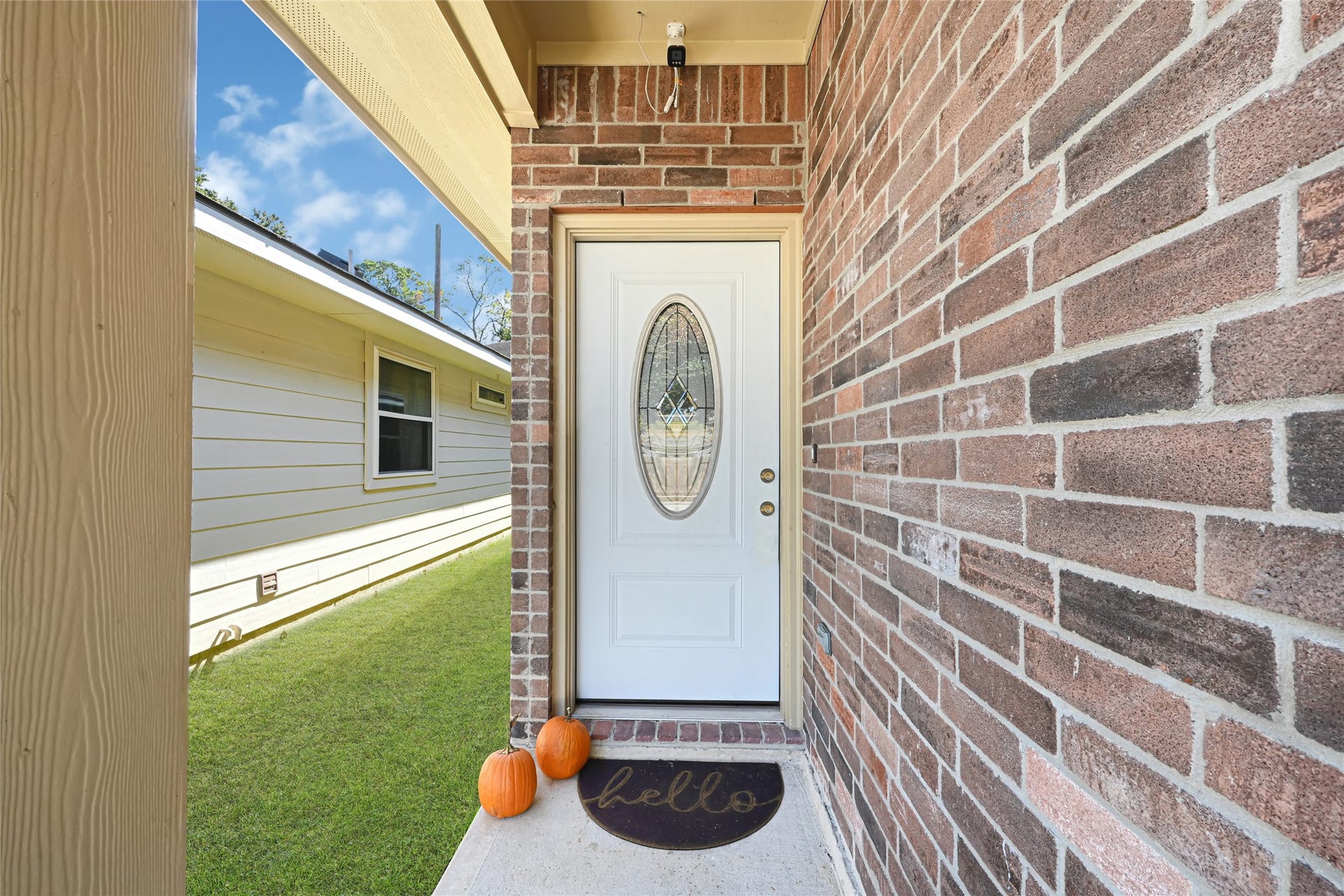 Charming front entrance with a stylish brick facade and a welcoming door featuring an elegant oval glass insert.