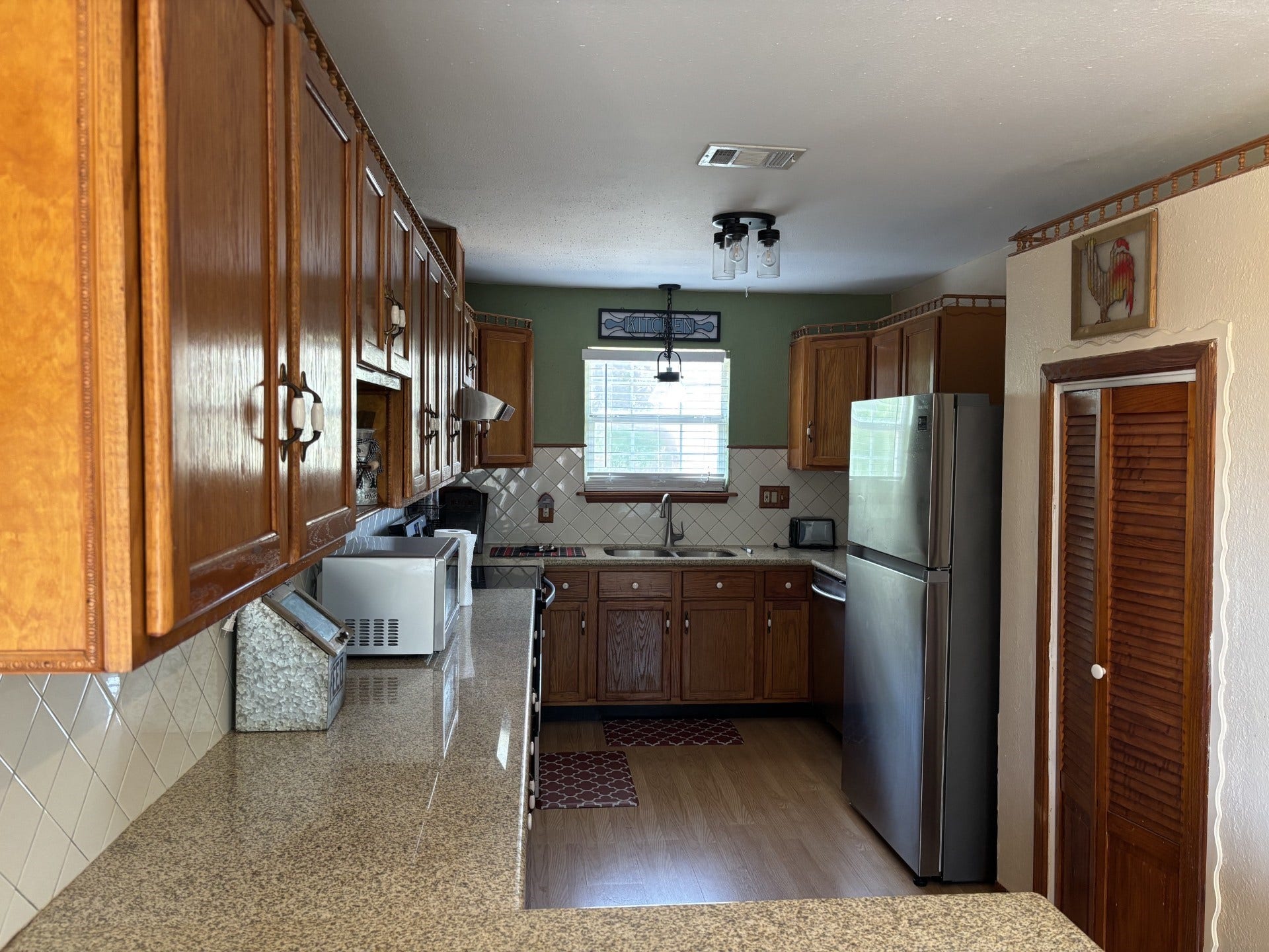 5324 Aurora Drive S, #CR378, Alvin, TX 77511 Kithchen with refrigerator, granite countertops, lots of storage with wood cabinets,, and pantry