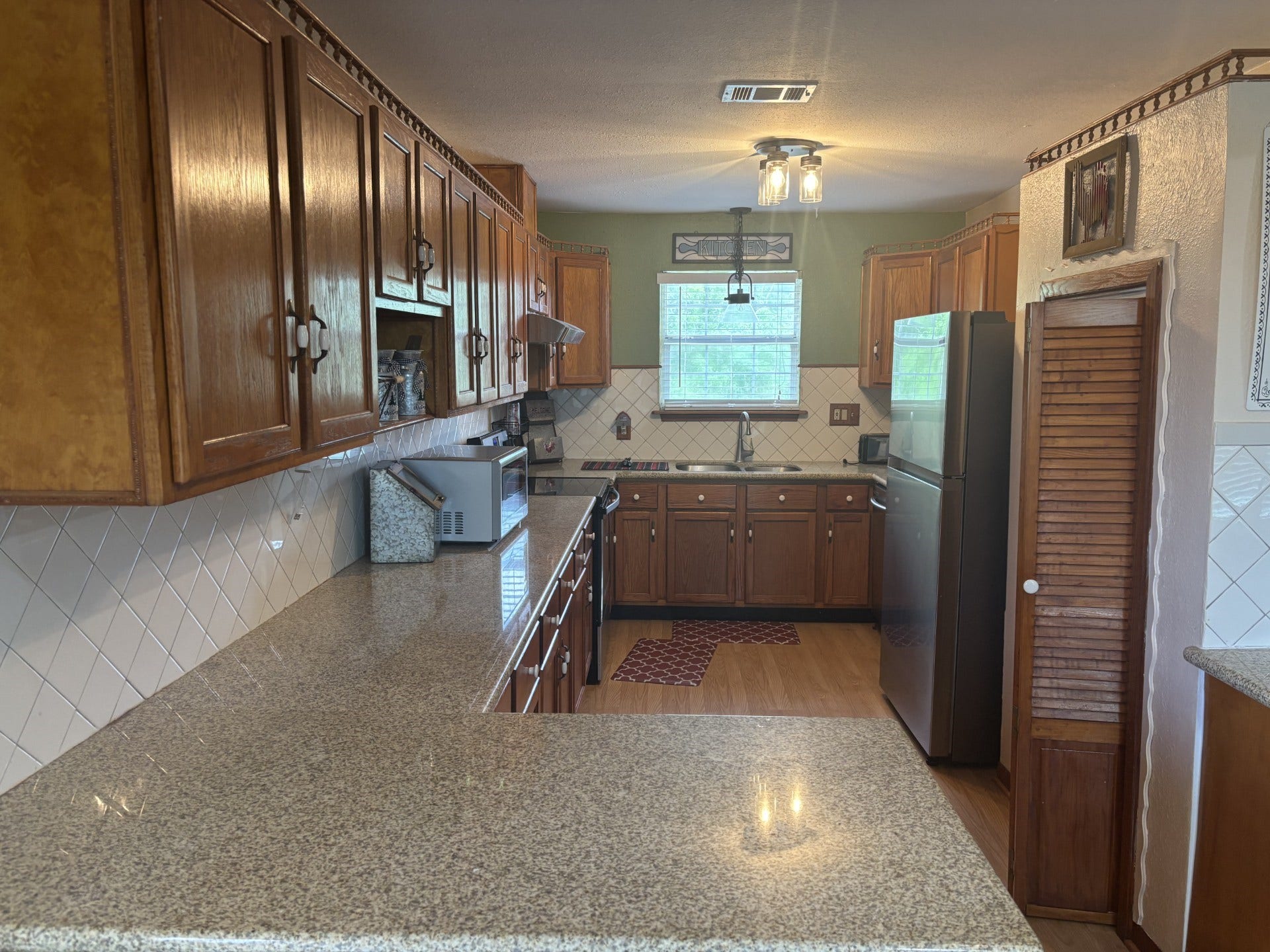 5324 Aurora Drive S, #CR378, Alvin, TX 77511 The kitchen boasts elegant wood cabinets, sleek granite countertops, and stylish wood-like flooring.