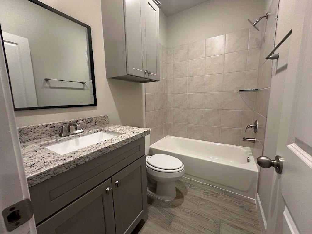 104 Turner Drive, Willis, TX 77378 Bright secondary bathroom showcasing contemporary finishes, sleek stone vanity, and neutral tilework.