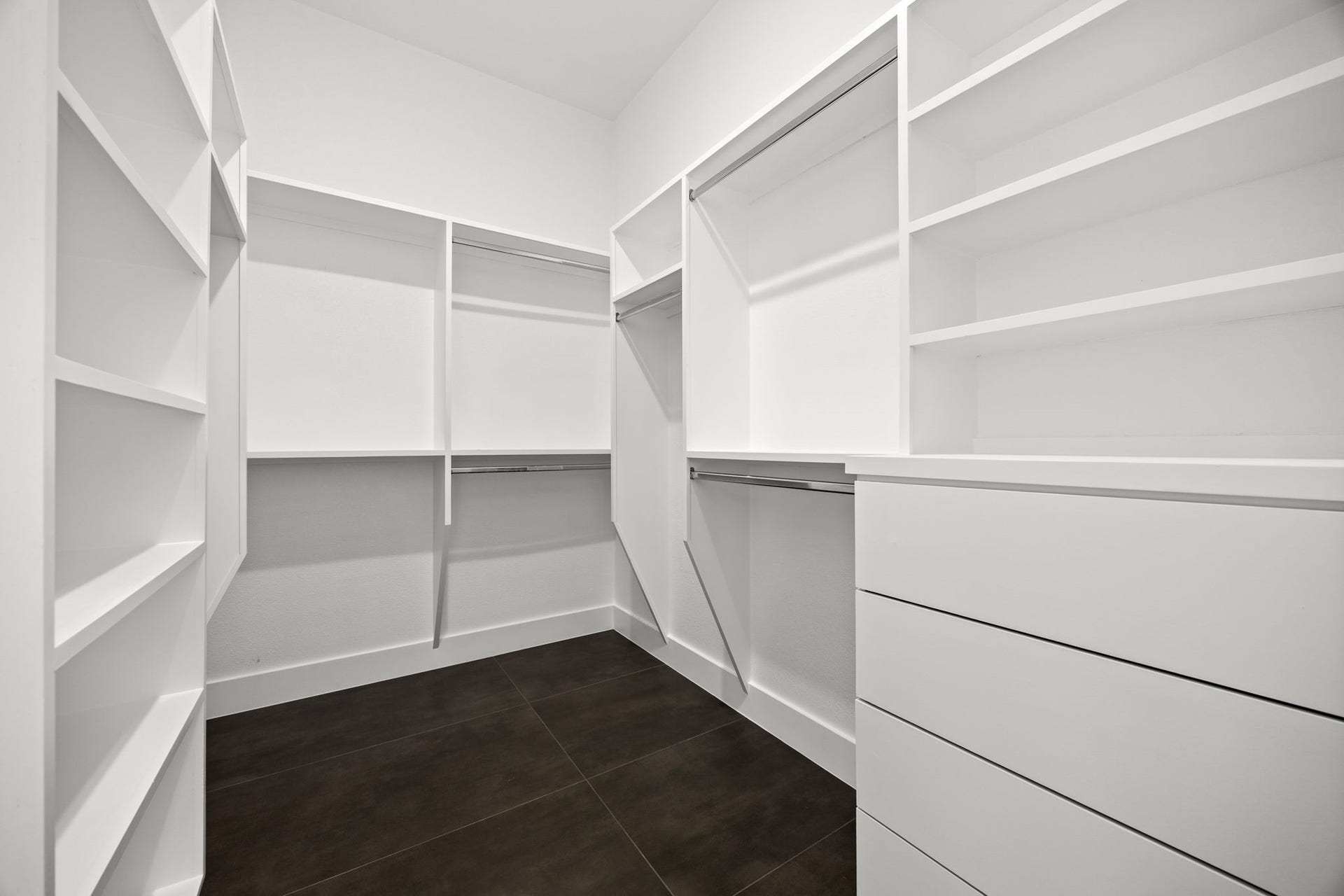 98 Camden Hills Drive, Montgomery, TX 77356 Spacious walk-in closet with ample shelving, hanging space, and modern dark flooring, perfect for organized storage.