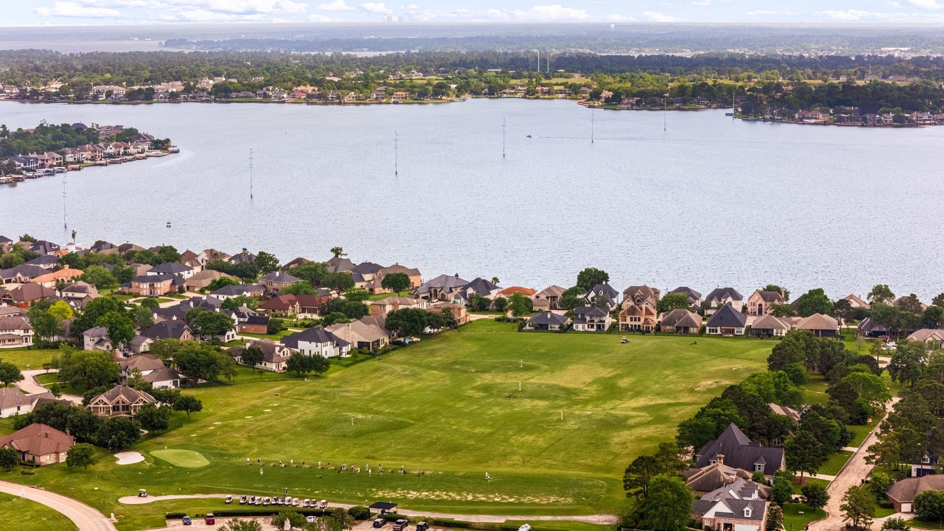 98 Camden Hills Drive, Montgomery, TX 77356 This photo showcases a serene lakeside community with spacious homes, lush greenery, and stunning water views, perfect for those seeking a peaceful, scenic living environment.