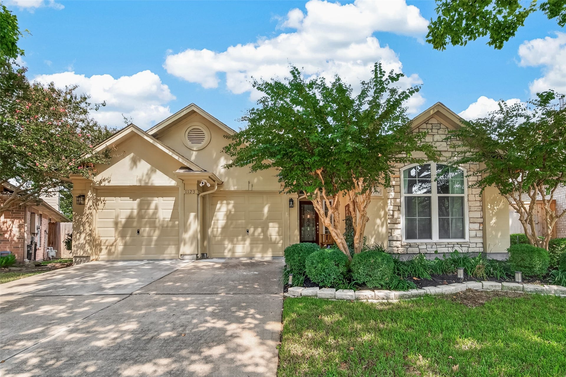 1123 Parkhaven Lane, Houston, TX 77077 Inviting front exterior with two separate garage doors, stone accents and a large arched window. Established landscaping frames the entry and adds to the homes curb appeal.