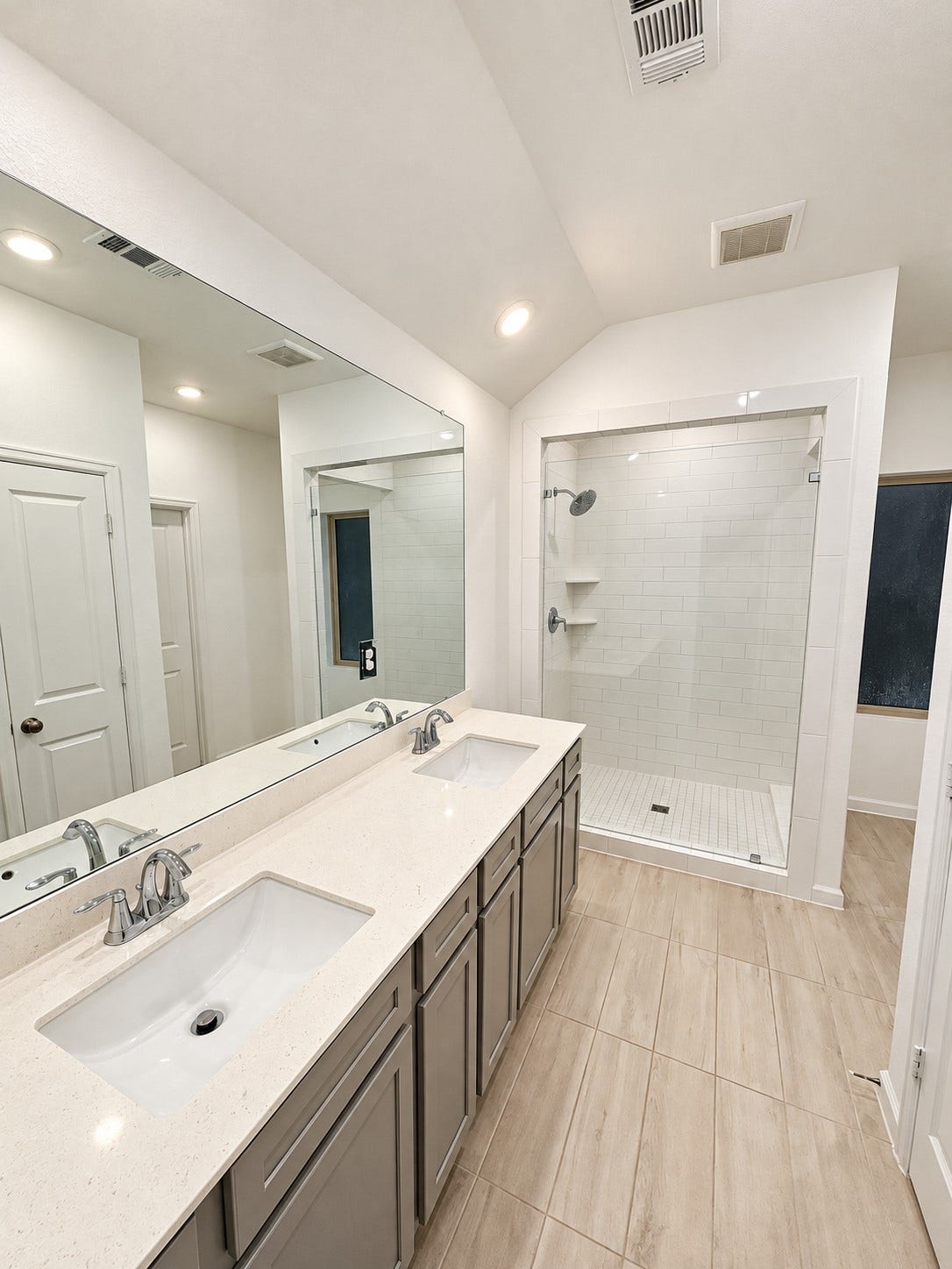 9. Primary bathroom featuring a dual-sink vanity and a glass-enclosed shower.