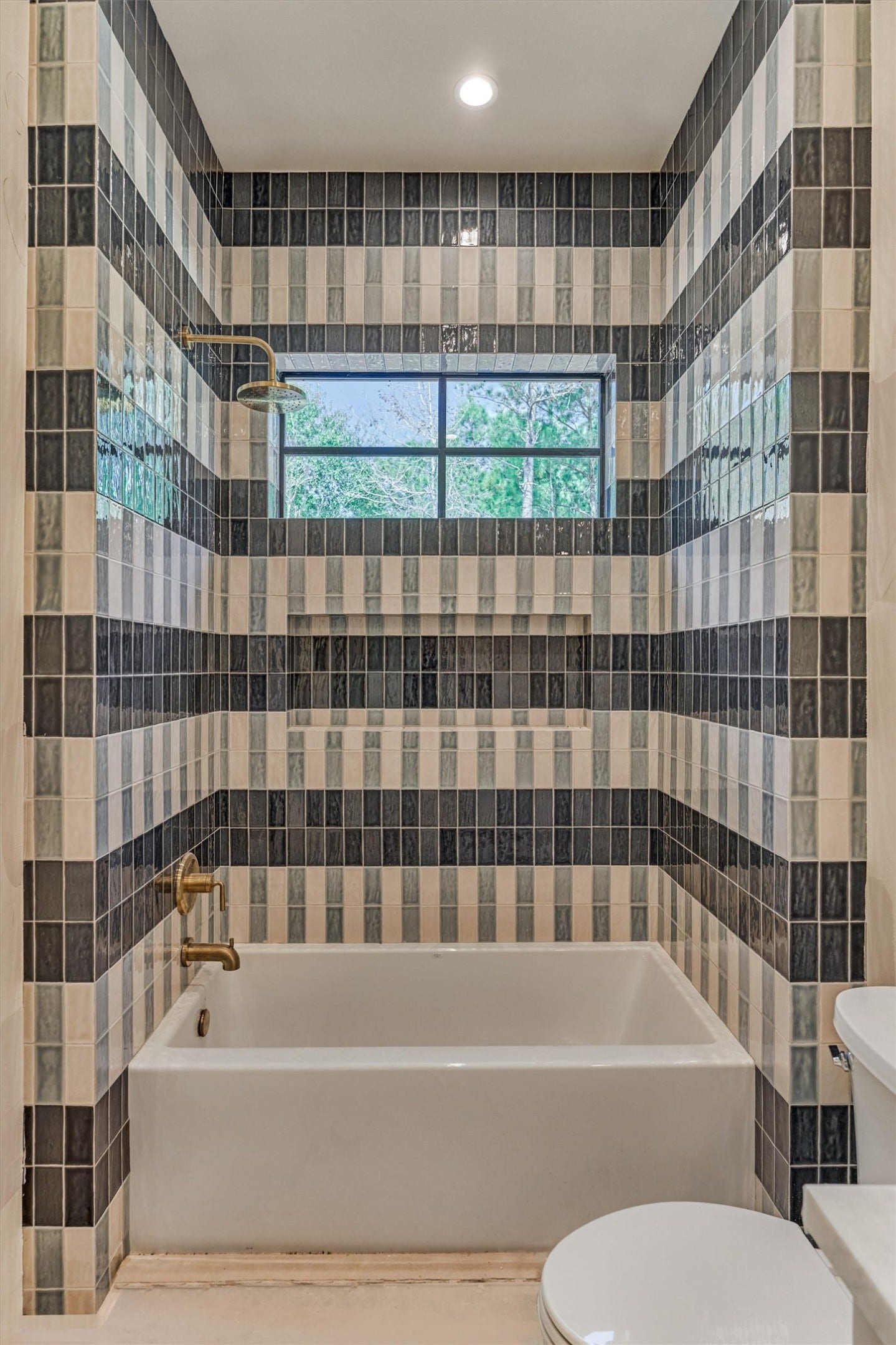 4800 Hawk Canyon Court, Montgomery, TX 77316 This space reflects a calm elevated design, featuring carefully selected tile in layered color and pattern. This shower/ tub combo is a dedicated space to a secondary bedroom.