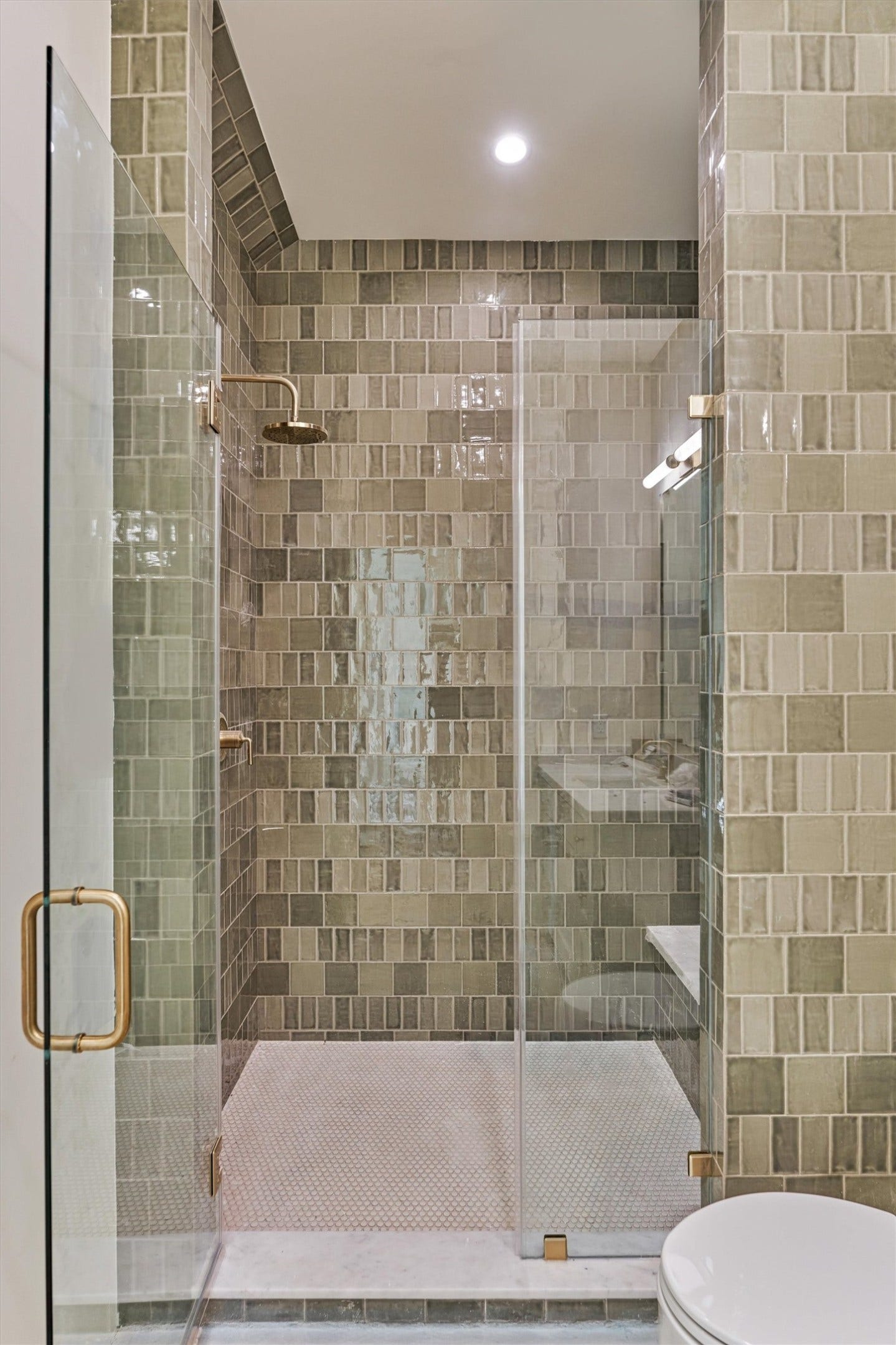 4800 Hawk Canyon Court, Montgomery, TX 77316 Another ensuite bath showcasing a walk in shower with a generous built in bench and sophisticated tile selection.