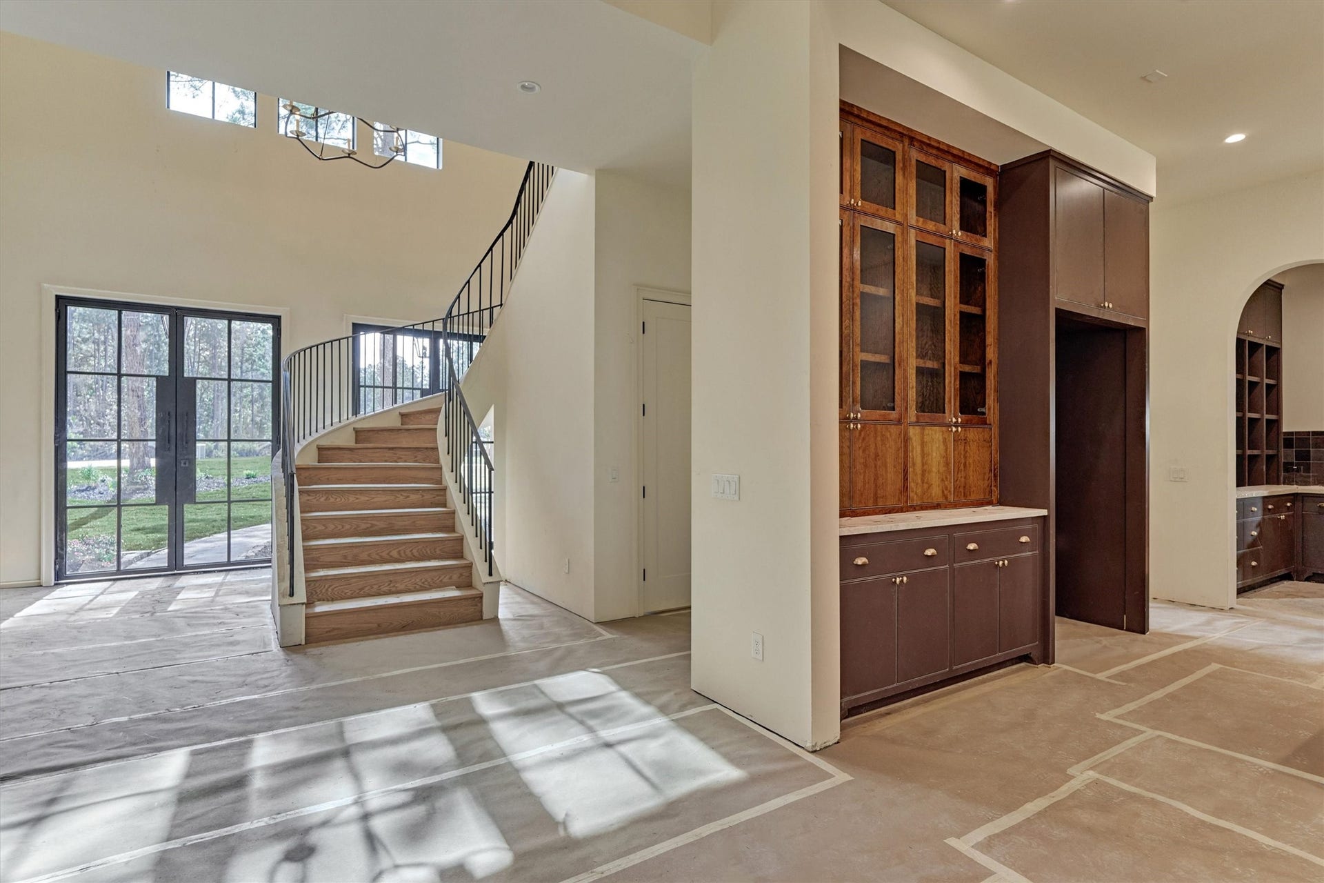 4800 Hawk Canyon Court, Montgomery, TX 77316 Perspective of the grand entry as it transitions into the expansive living area and the heart of the home (The Kitchen). Thoughtful architectural design offers a glimpse of the secondary prep kitchen beyond.