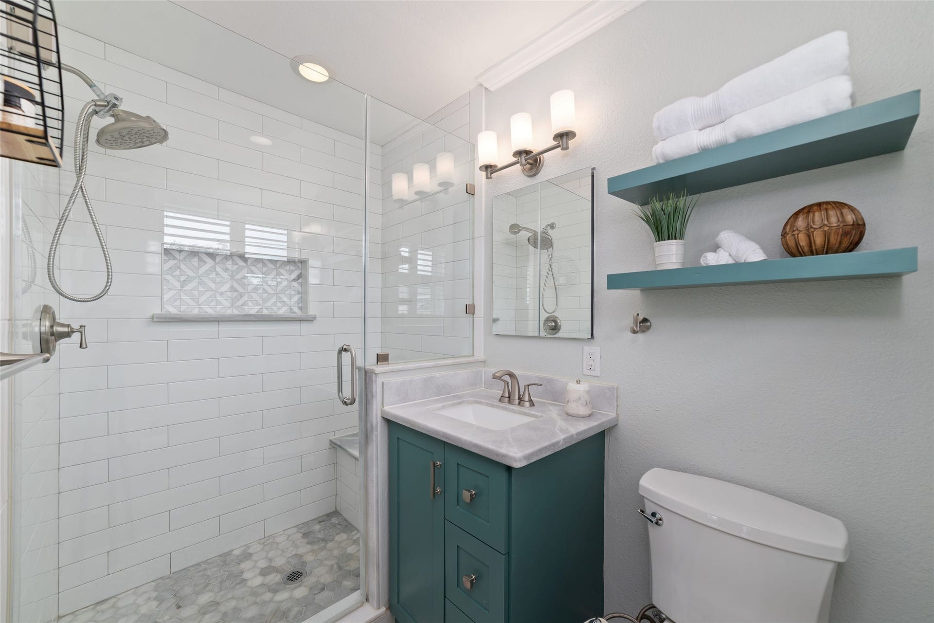 2127 Lazybrook Drive, Houston, TX 77008 Elegant primary bath featuring a glass-enclosed shower with stylish tilework, a modern vanity and open shelving for storage.