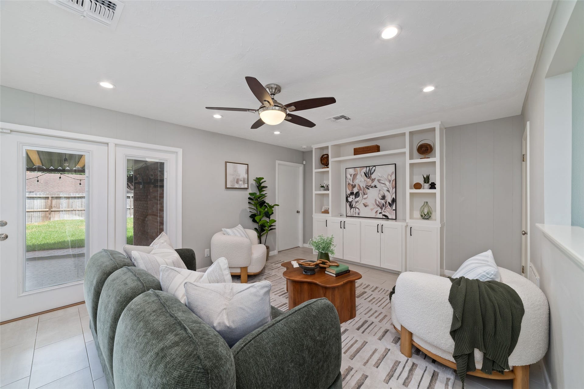 2127 Lazybrook Drive, Houston, TX 77008 Living room includes a built-in entertainment center and French doors that open to a spacious backyard, offering a seamless indoor-outdoor flow.