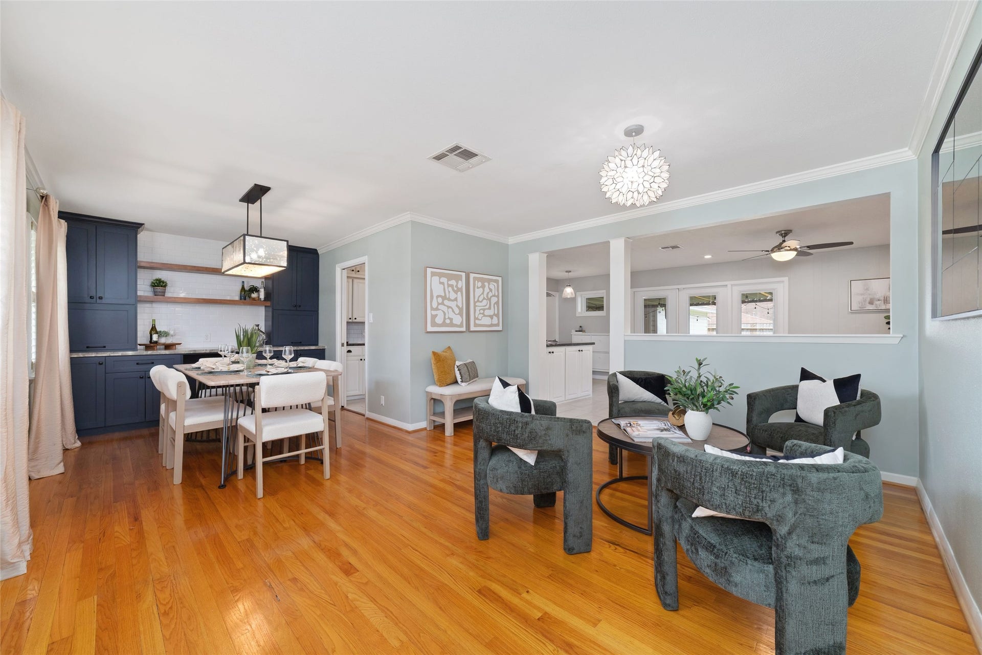 2127 Lazybrook Drive, Houston, TX 77008 Elegant open-concept dining and den area featuring hardwood floors and built in cabinetry.