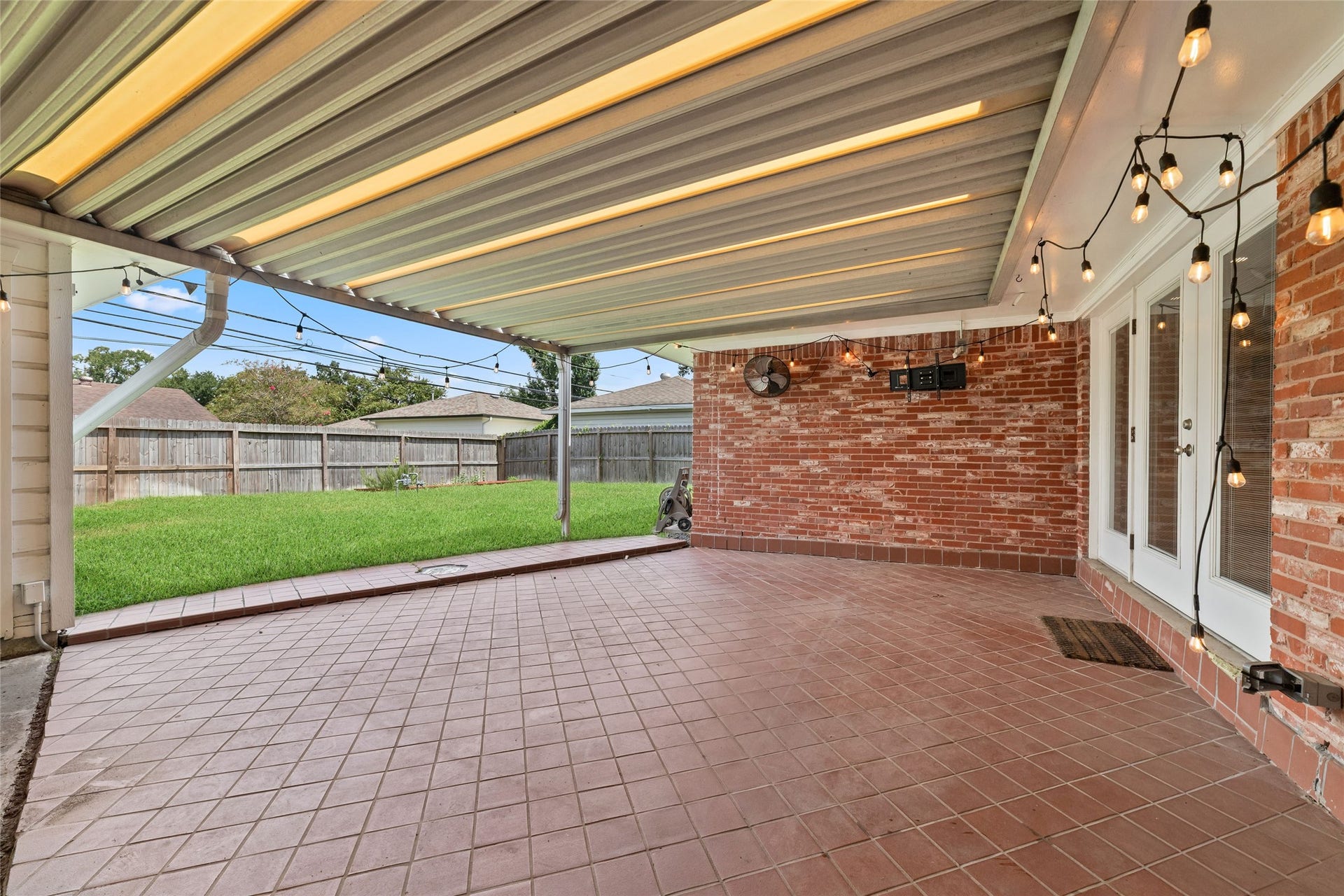 2127 Lazybrook Drive, Houston, TX 77008 Spacious covered patio perfect for outdoor entertaining, overlooking a lush green yard complete with raised garden beds.