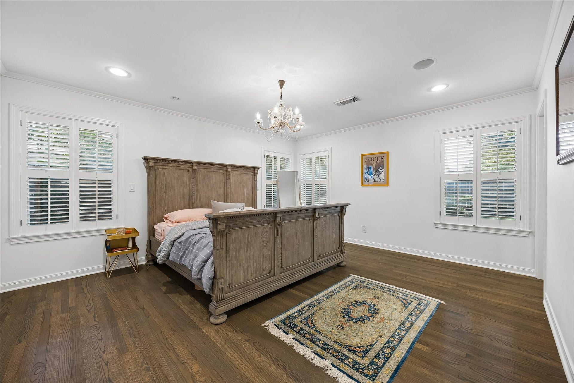 4703 Banning Drive, Houston, TX 77027 Spacious primary bedroom features beautiful hardwood floors, crown molding, recessed lighting & an elegant chandelier. Multiple windows w/plantation shutters fill the room w/natural light.