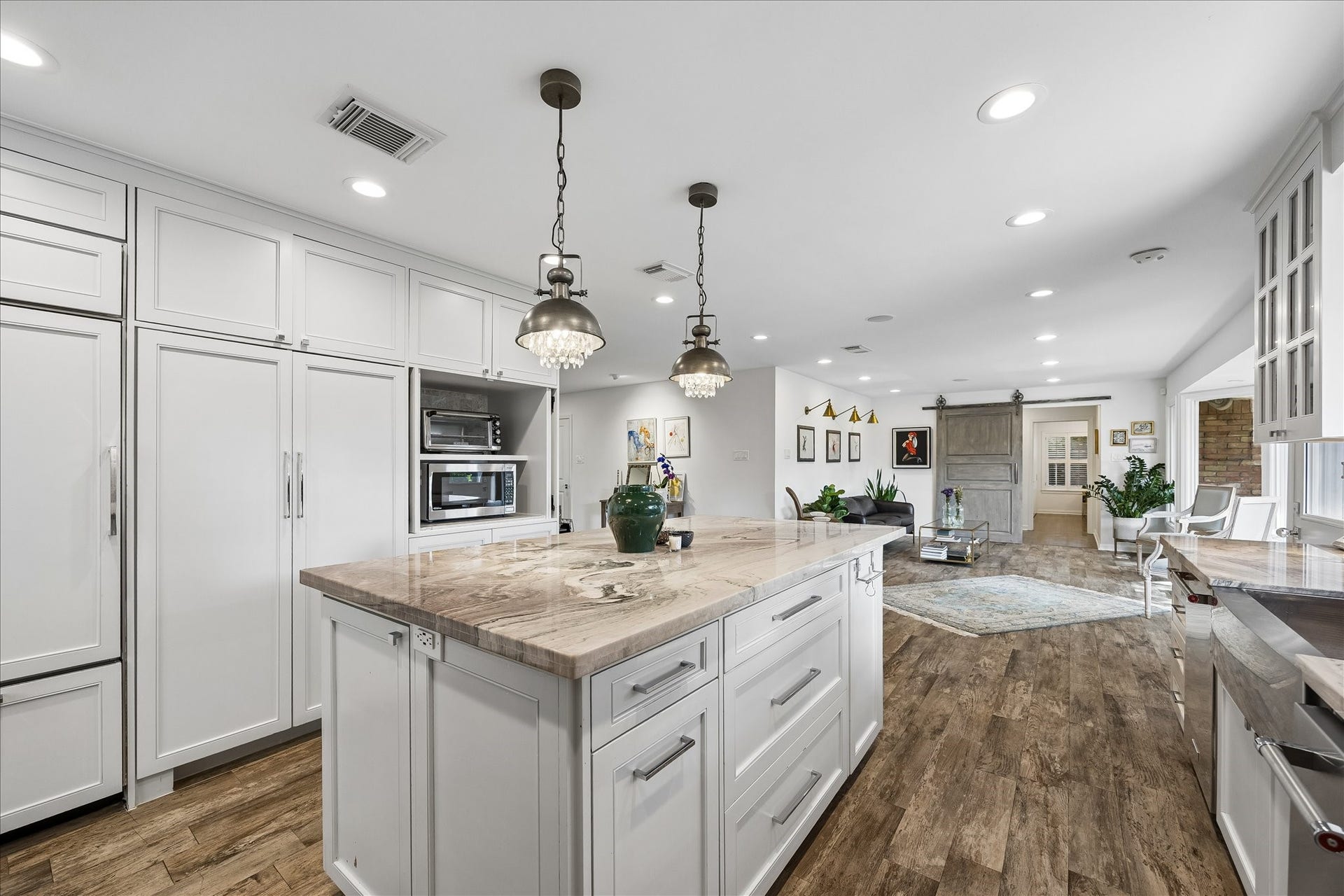 4703 Banning Drive, Houston, TX 77027 Kitchen offers exceptional storage w/floor-to-ceiling cabinetry, built-in appliances, spacious island w/additional drawers & recessed lighting. The open design connects effortlessly to the living area, creating a wonderful space for everyday living.