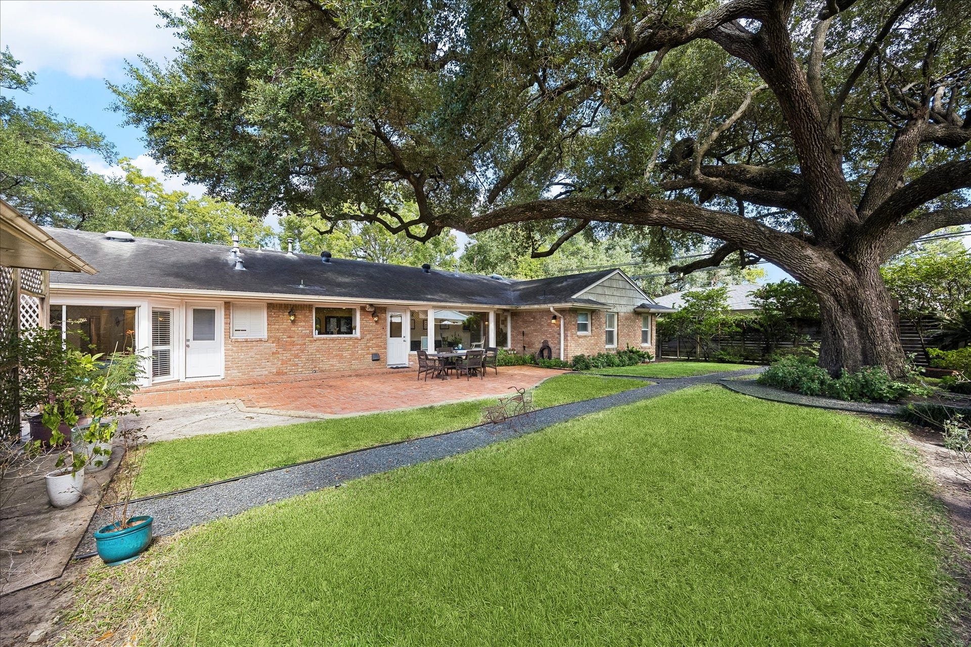 4703 Banning Drive, Houston, TX 77027 Expansive backyard offers a beautiful setting w/lush green lawn, mature tree, colorful landscaping & winding gravel pathways. Large brick patio provides wonderful space for outdoor dining, entertaining & enjoying the peaceful surroundings.