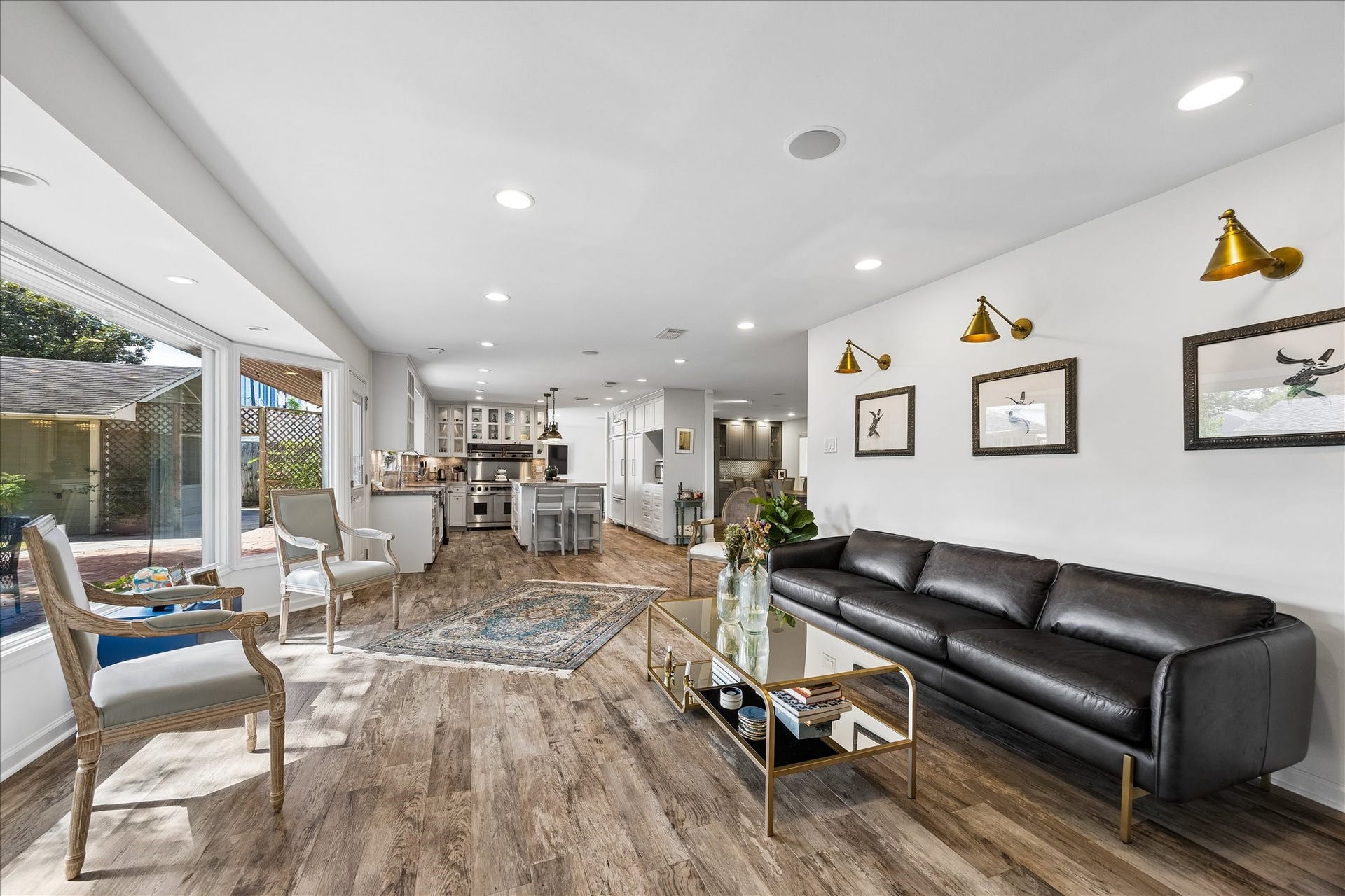 4703 Banning Drive, Houston, TX 77027 Living area flows seamlessly into the updated kitchen, creating a wonderful open-concept layout. Expansive windows, wood flooring & recessed lighting enhance this inviting space, ideal for everyday living & entertaining.