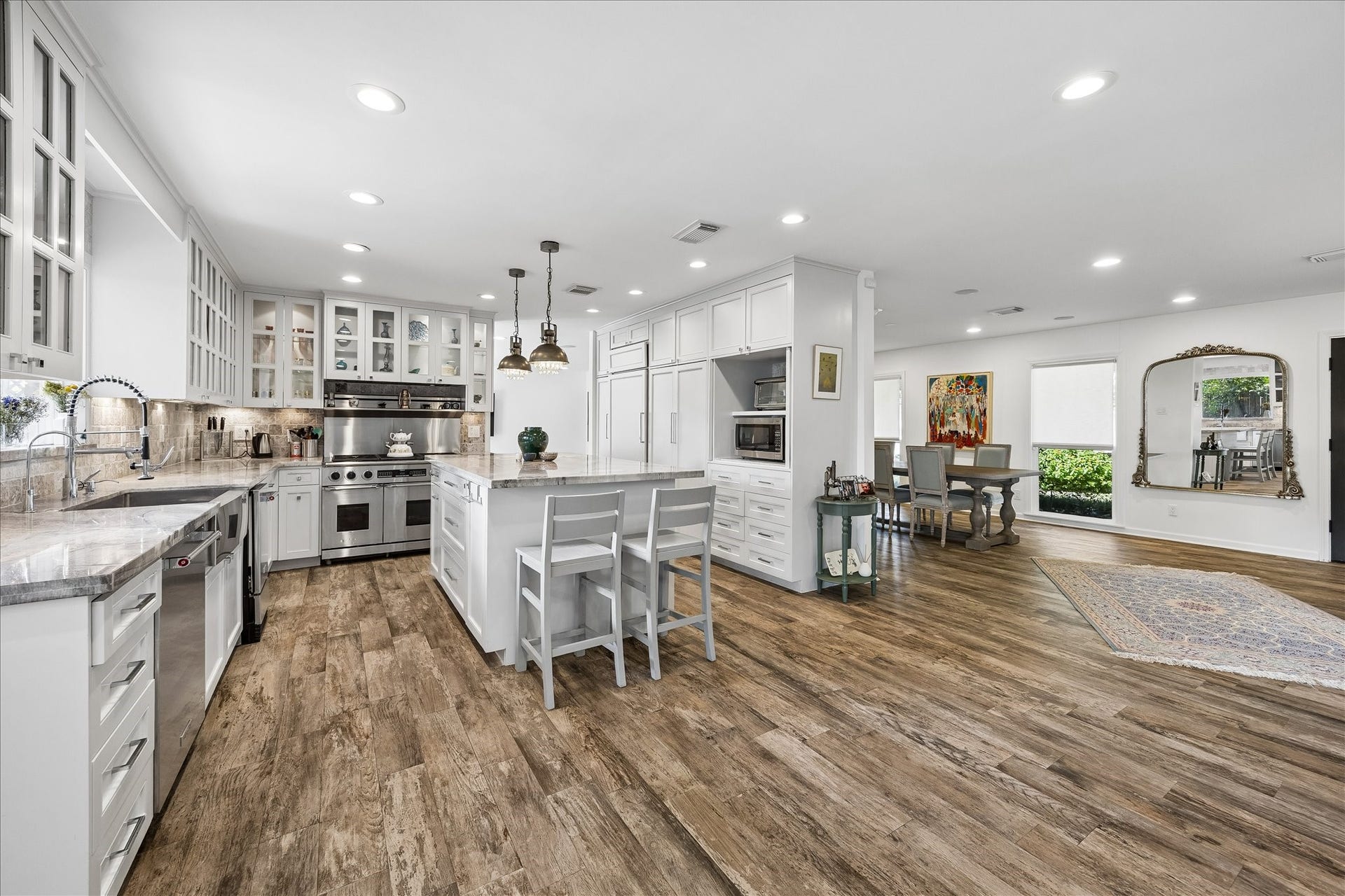 4703 Banning Drive, Houston, TX 77027 Spacious open-concept kitchen & dining area features beautiful wood-look flooring, extensive custom cabinetry, stainless steel appliances & a large island w/breakfast bar seating. The adjoining dining area offers wonderful natural light & flexibility for entertaining.