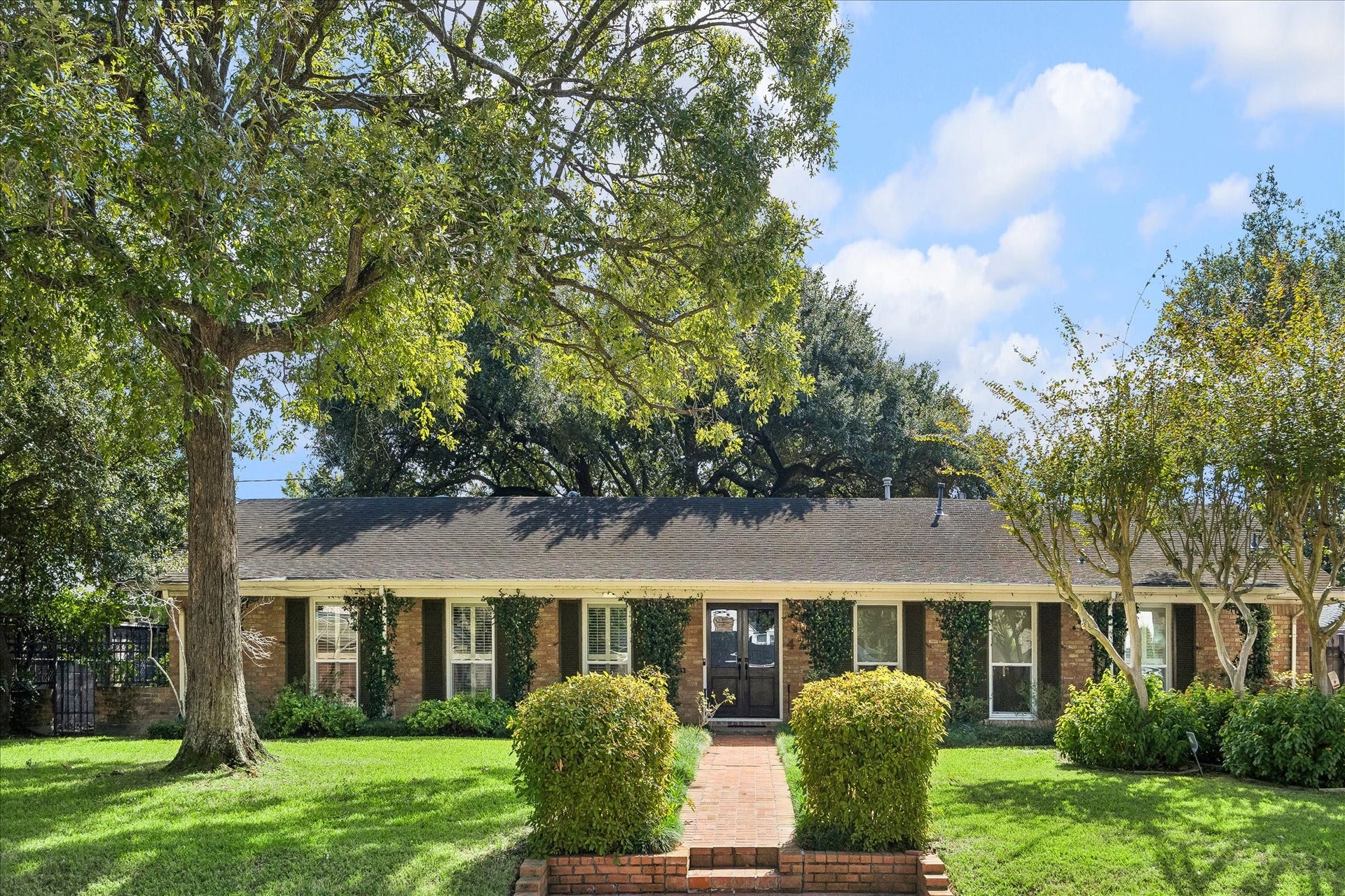 4703 Banning Drive, Houston, TX 77027 This home showcases a beautiful brick exterior, mature shade trees, manicured landscaping & brick walkway leading to the welcoming double-door entry.