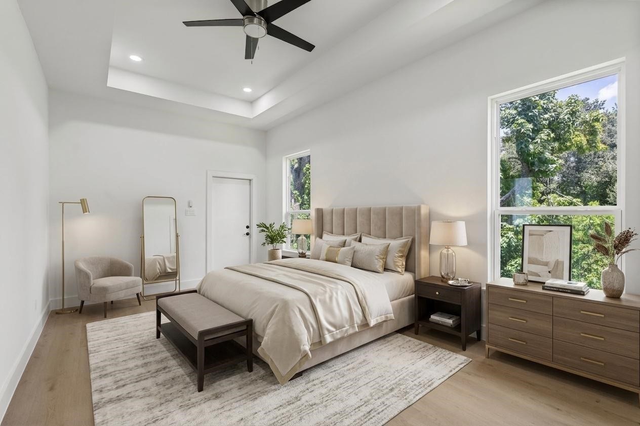 Spacious and elegant bedroom featuring a plush bed, modern furniture, and large windows that fill the space with natural light and offer serene views.