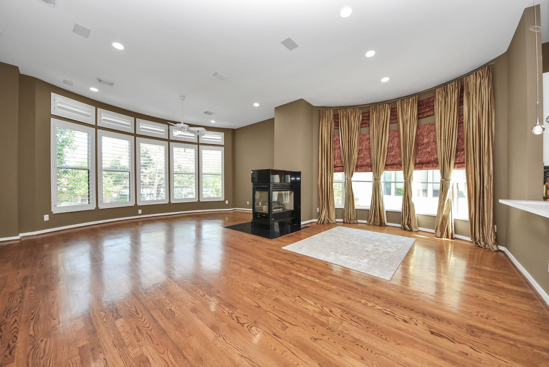 6519 Durford Street, Houston, TX 77007 Second floor Expansive living space with rich hardwood floors, soaring ceilings, and walls of windows that flood the room with natural light, anchored by a sleek modern fireplace.