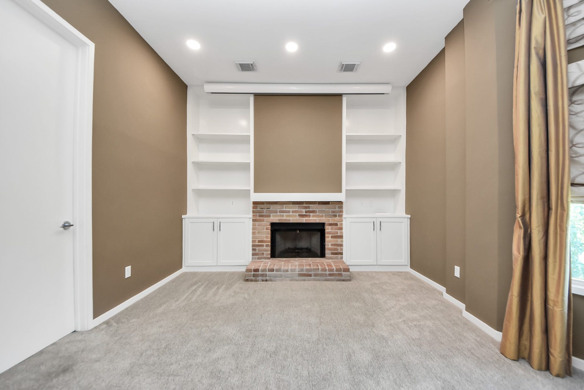 6519 Durford Street, Houston, TX 77007 Primary bedroom featuring a built-in projector, cozy fireplace, and custom built-ins.