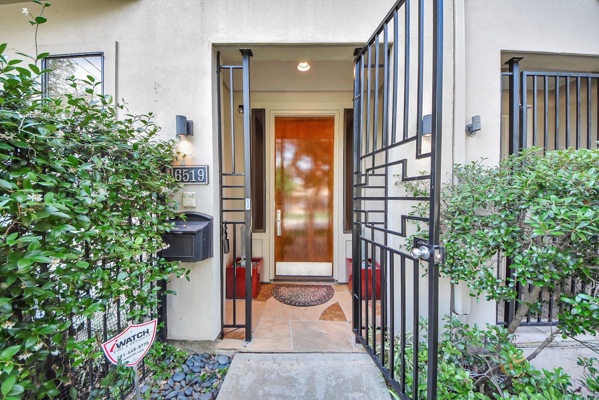 6519 Durford Street, Houston, TX 77007 Inviting covered front entry with secure gated access, surrounded by lush landscaping and a beautifully maintained walkway.