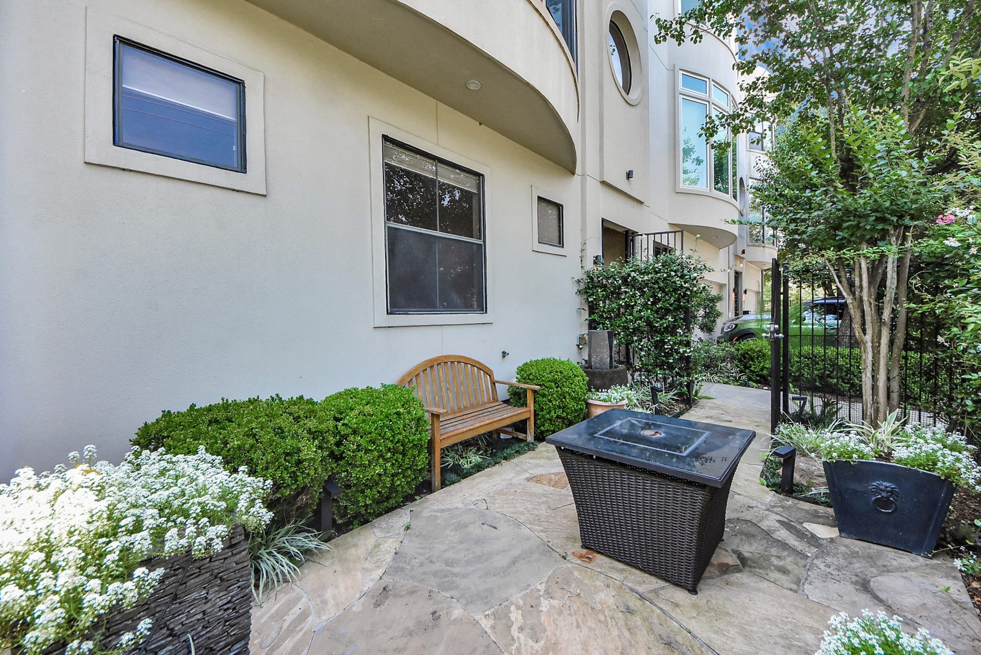 6519 Durford Street, Houston, TX 77007 Beautiful covered front patio with stone flooring, lush landscaping, and a cozy seating areaperfect for relaxing outdoors.