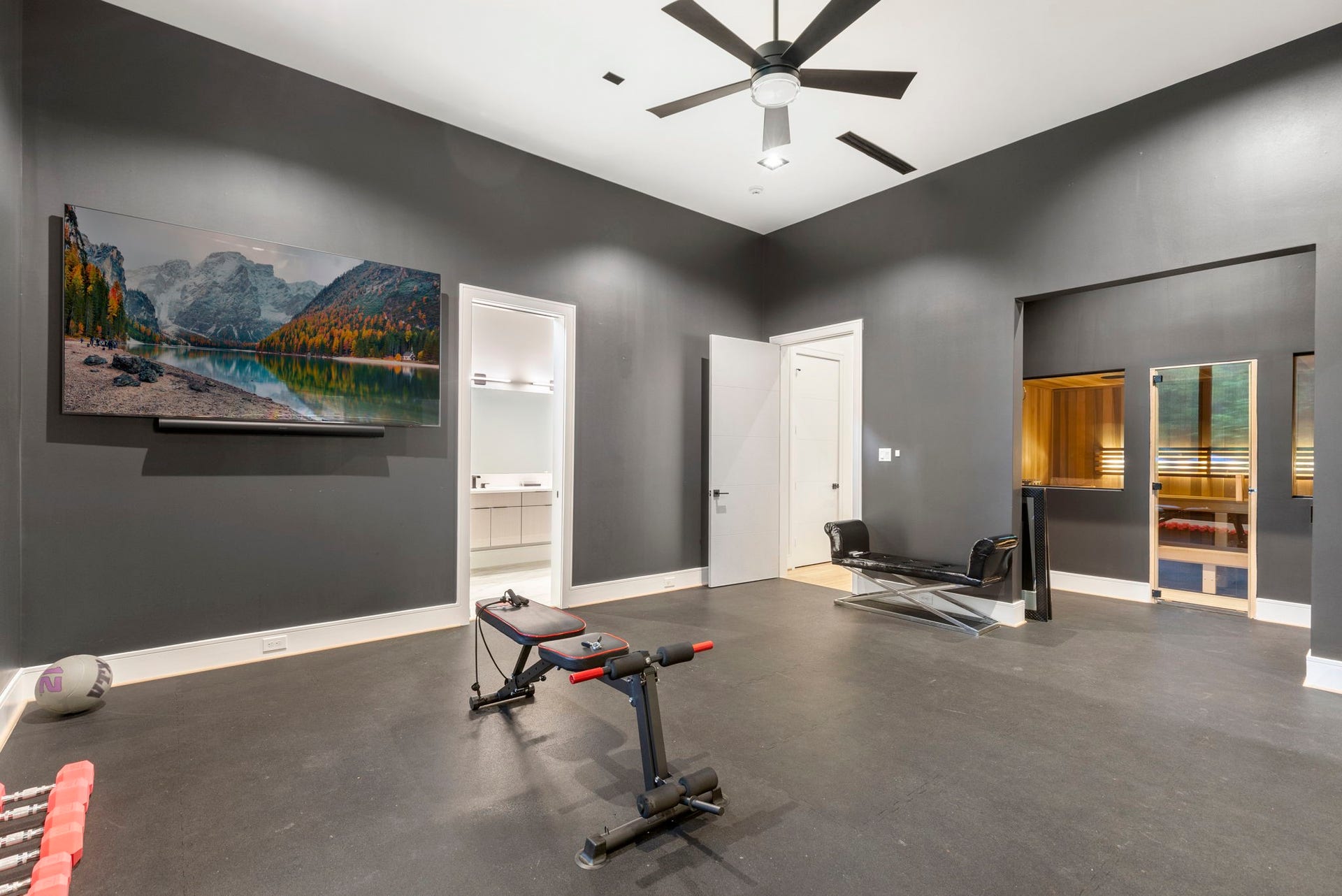 A private wellness room has generous space for equipment with a full en suite bath and sauna.  This space easily converts to an additional secondary bedroom down.