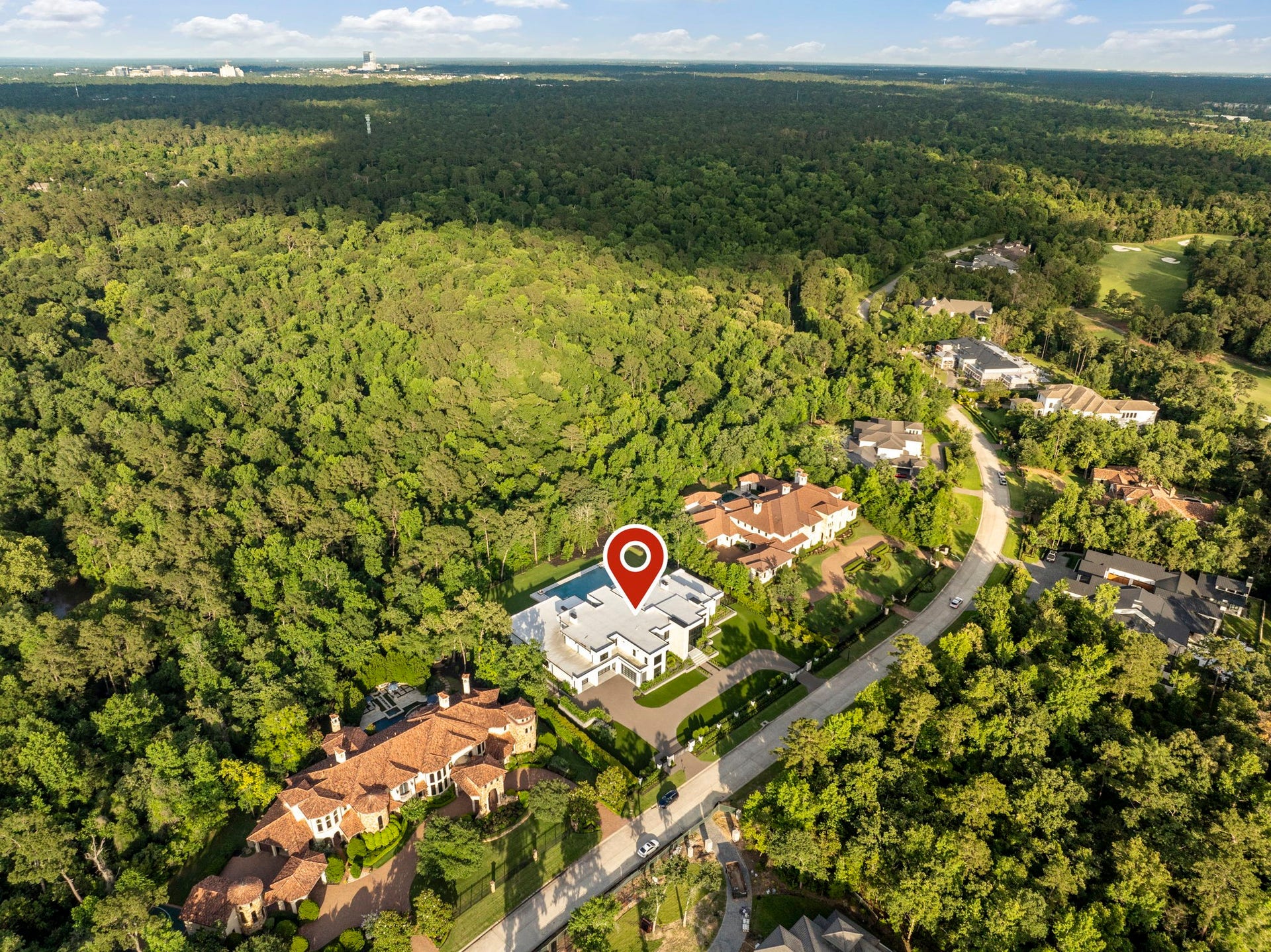 1.4-acre modern estate borders the George Mitchell Nature Preserve.