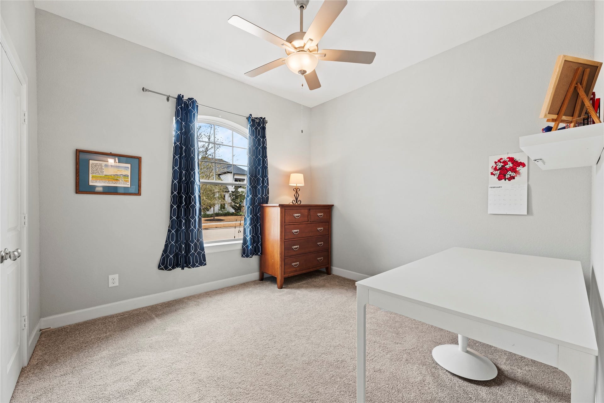 3127 Swift Way, Katy, TX 77493 Bright and welcoming fourth bedroom with soft carpeting, a ceiling fan, and a large arched window offering plenty of natural light.