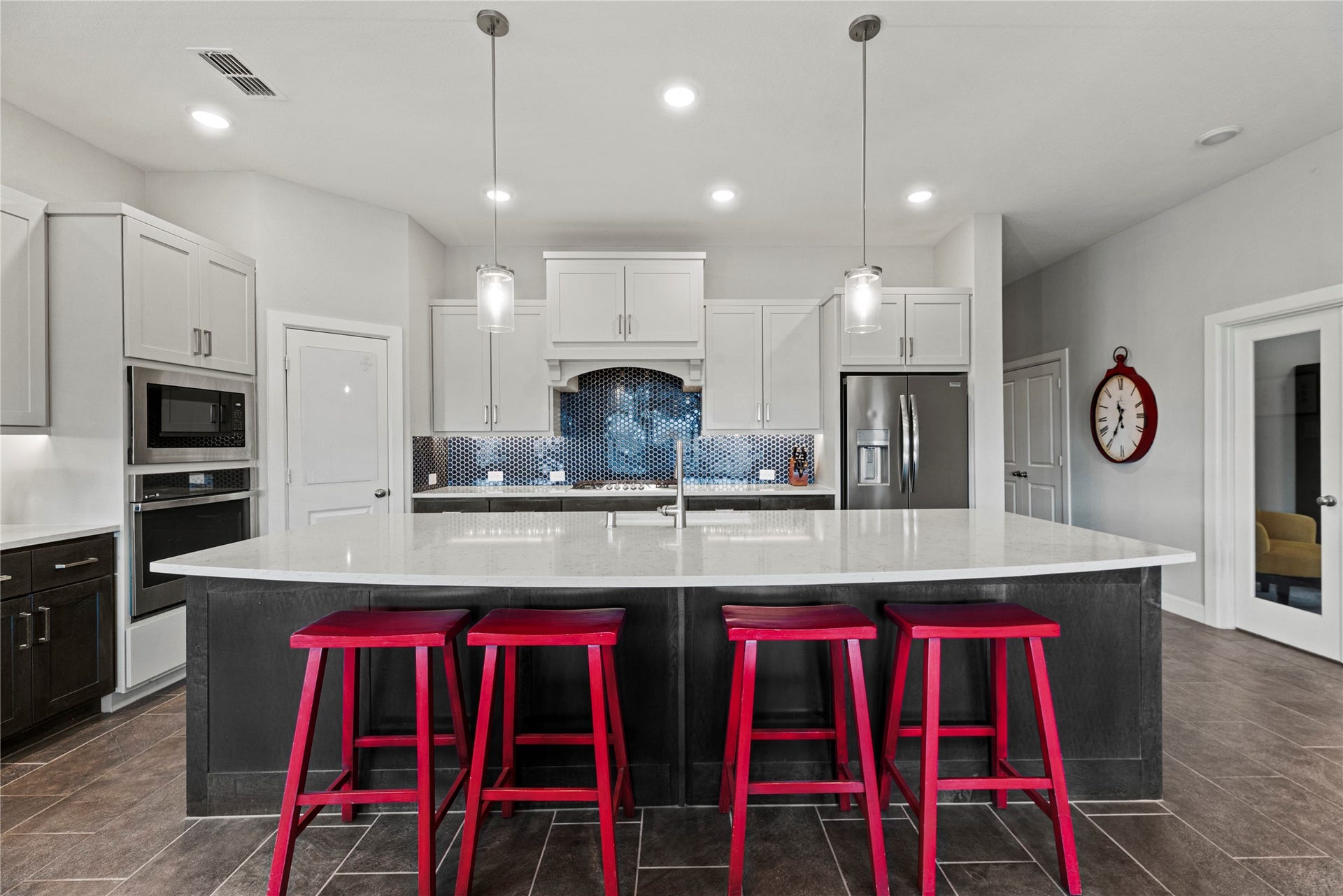 3127 Swift Way, Katy, TX 77493 Spacious modern kitchen with a large island, sleek quartz countertops complemented by stainless steel appliances and stylish pendant lighting.