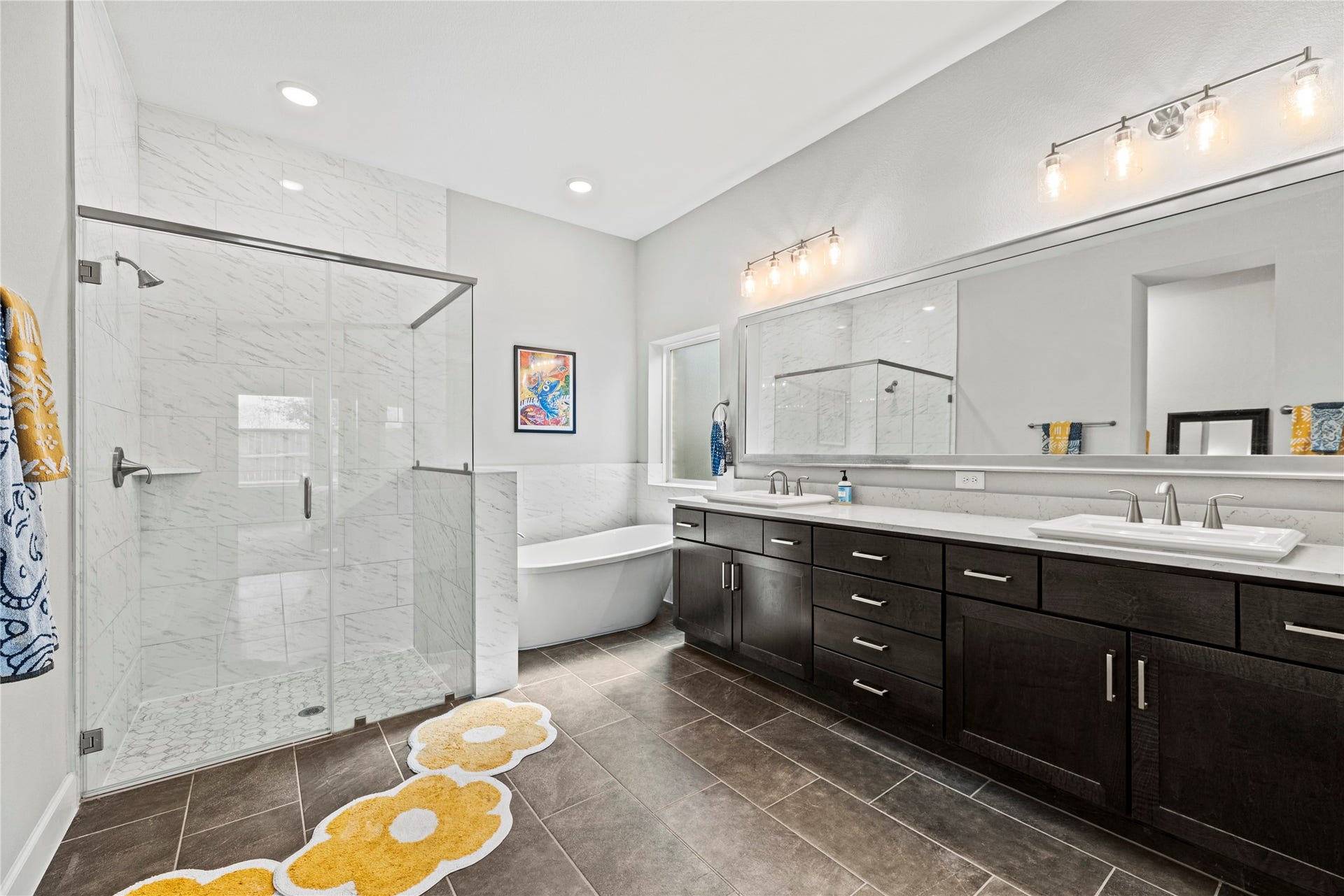 3127 Swift Way, Katy, TX 77493 Spacious and modern primary bathroom featuring a sleek glass-enclosed shower, a luxurious freestanding tub, and a double vanity with ample storage beneath elegant lighting.