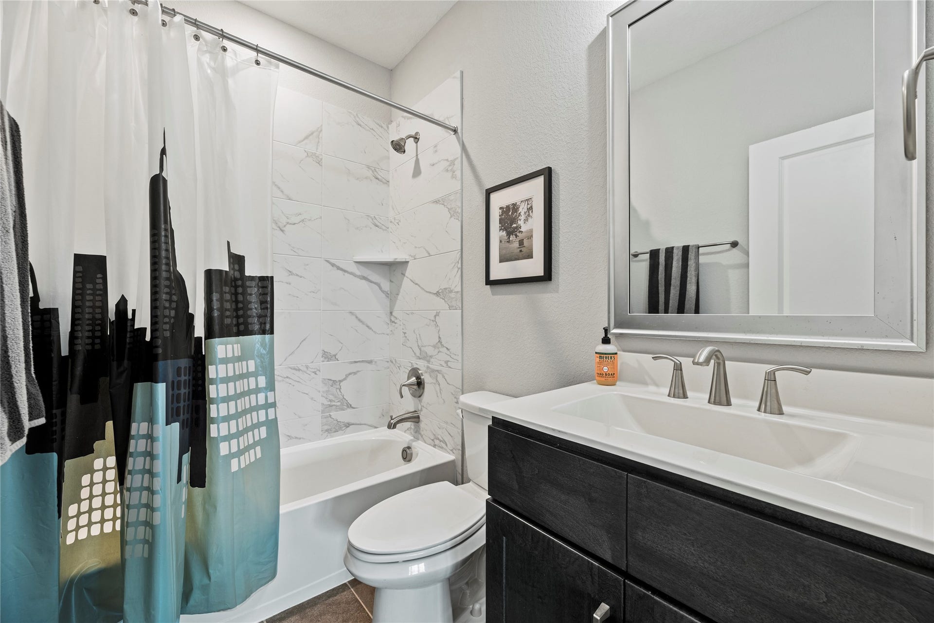 3127 Swift Way, Katy, TX 77493 Modern secondary bathroom featuring a sleek vanity, stylish fixtures, complemented by elegant tile in the shower area.