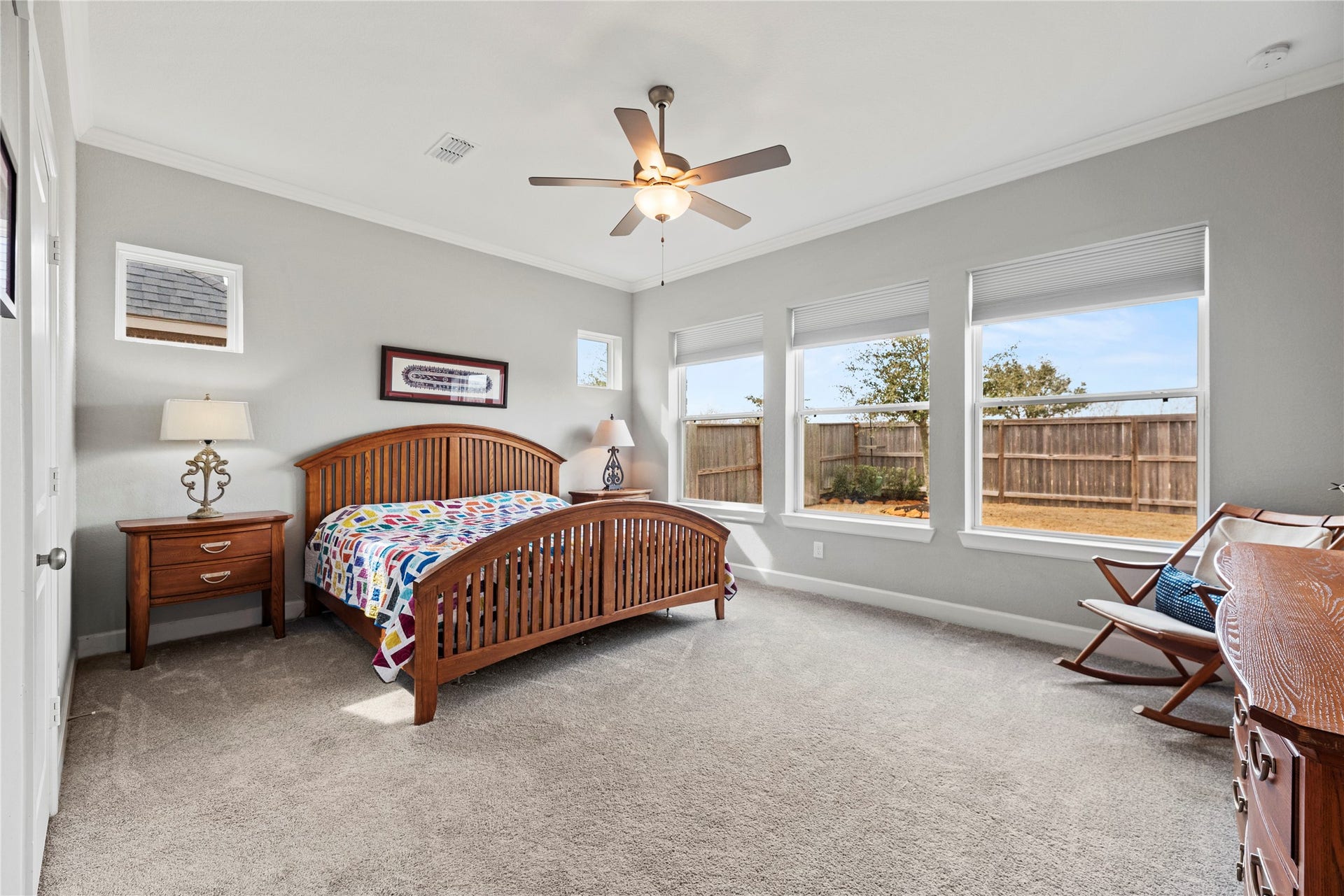 3127 Swift Way, Katy, TX 77493 Spacious primary bedroom featuring large windows that provide abundant natural light, a ceiling fan, and cozy carpeted flooring, and plenty of space!