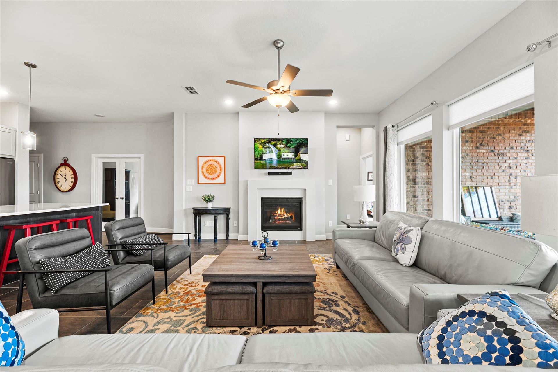 3127 Swift Way, Katy, TX 77493 Spacious living area with a cozy fireplace and abundant natural light from large windows, perfect for relaxation and entertaining.