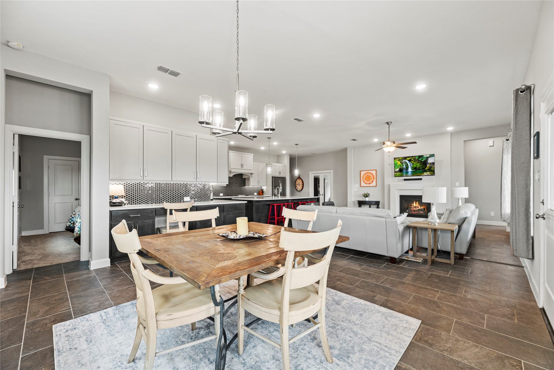 3127 Swift Way, Katy, TX 77493 Spacious open-concept living area with a modern kitchen featuring sleek cabinetry and a charming dining space. Cozy living room with a fireplace and ample natural light offers a perfect setting for relaxation and entertainment.