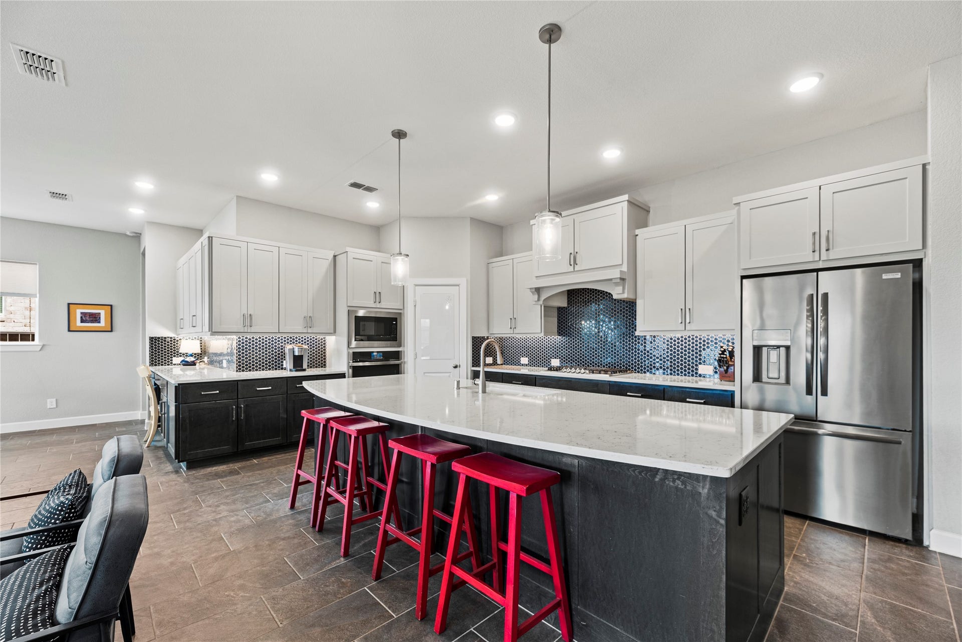 3127 Swift Way, Katy, TX 77493 Modern kitchen with sleek white cabinetry, a large island featuring quartz countertops.