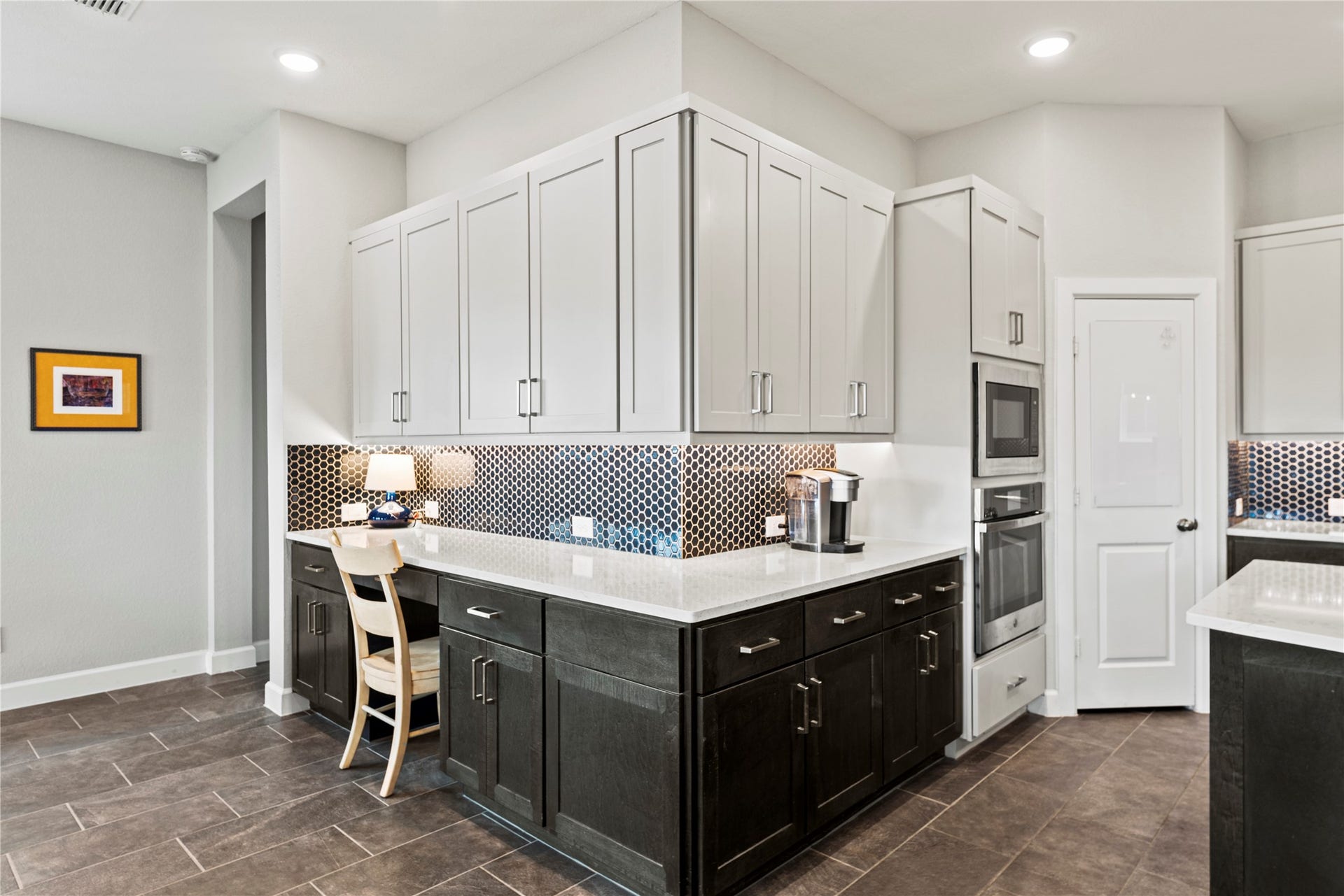 3127 Swift Way, Katy, TX 77493 Sleek modern kitchen featuring elegant two-tone cabinetry, a stylish hexagon backsplash, and high-end stainless steel appliances, perfect for culinary enthusiasts.