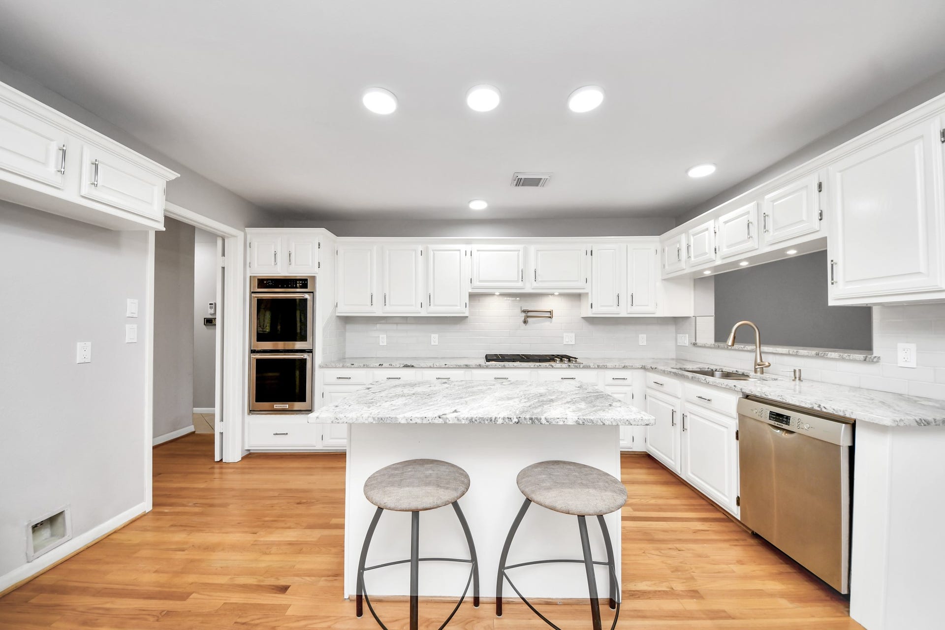 Bright, updated kitchen offers generous cabinetry, granite counters and a center prep island with casual seating.