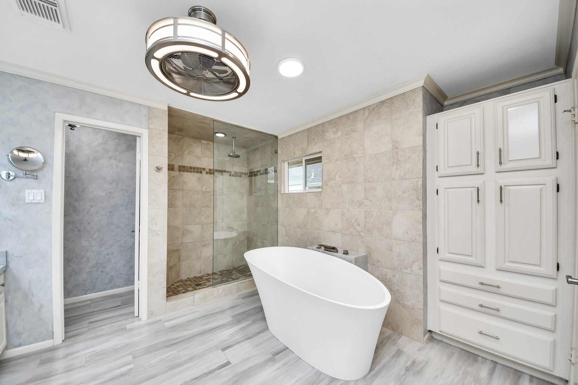 Beautifully remodeled primary bath features a freestanding Jacuzzi brand soaking tub, oversized walk-in shower and extensive built-in storage.