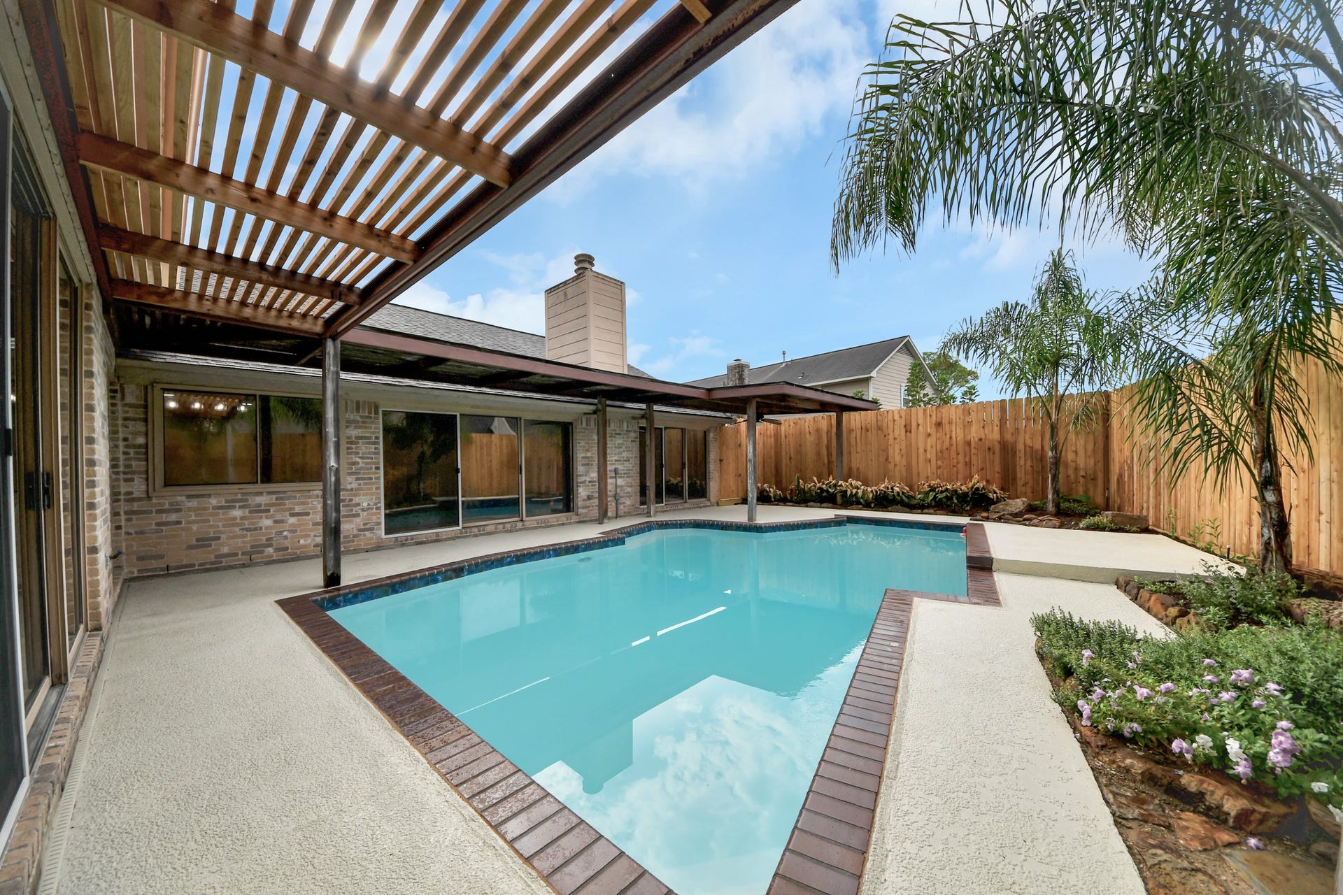 Private backyard pool is surrounded by generous patio space and multiple covered areas for shade and outdoor enjoyment.